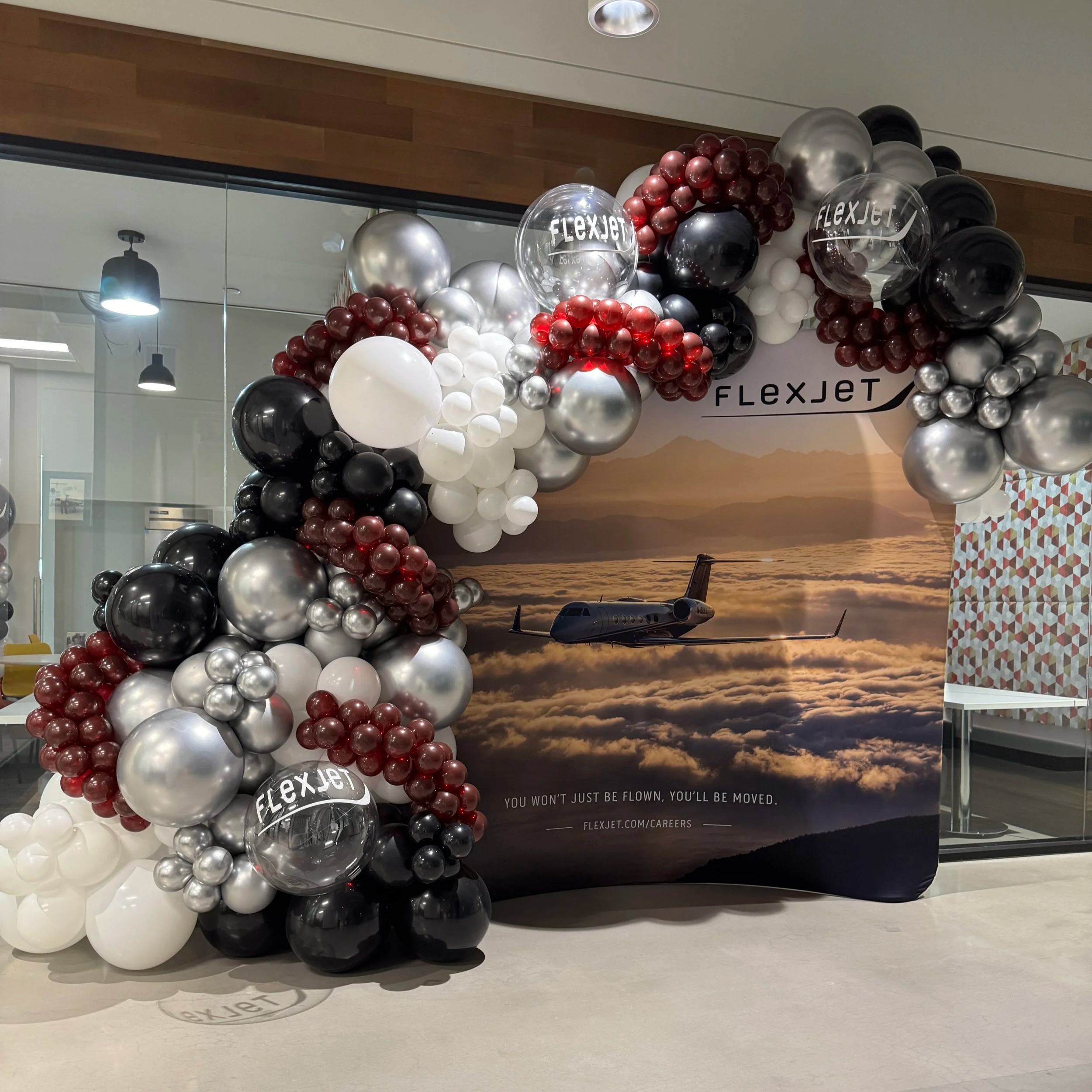 Balloon garland featuring company logos on branded strep and repeat in Dallas