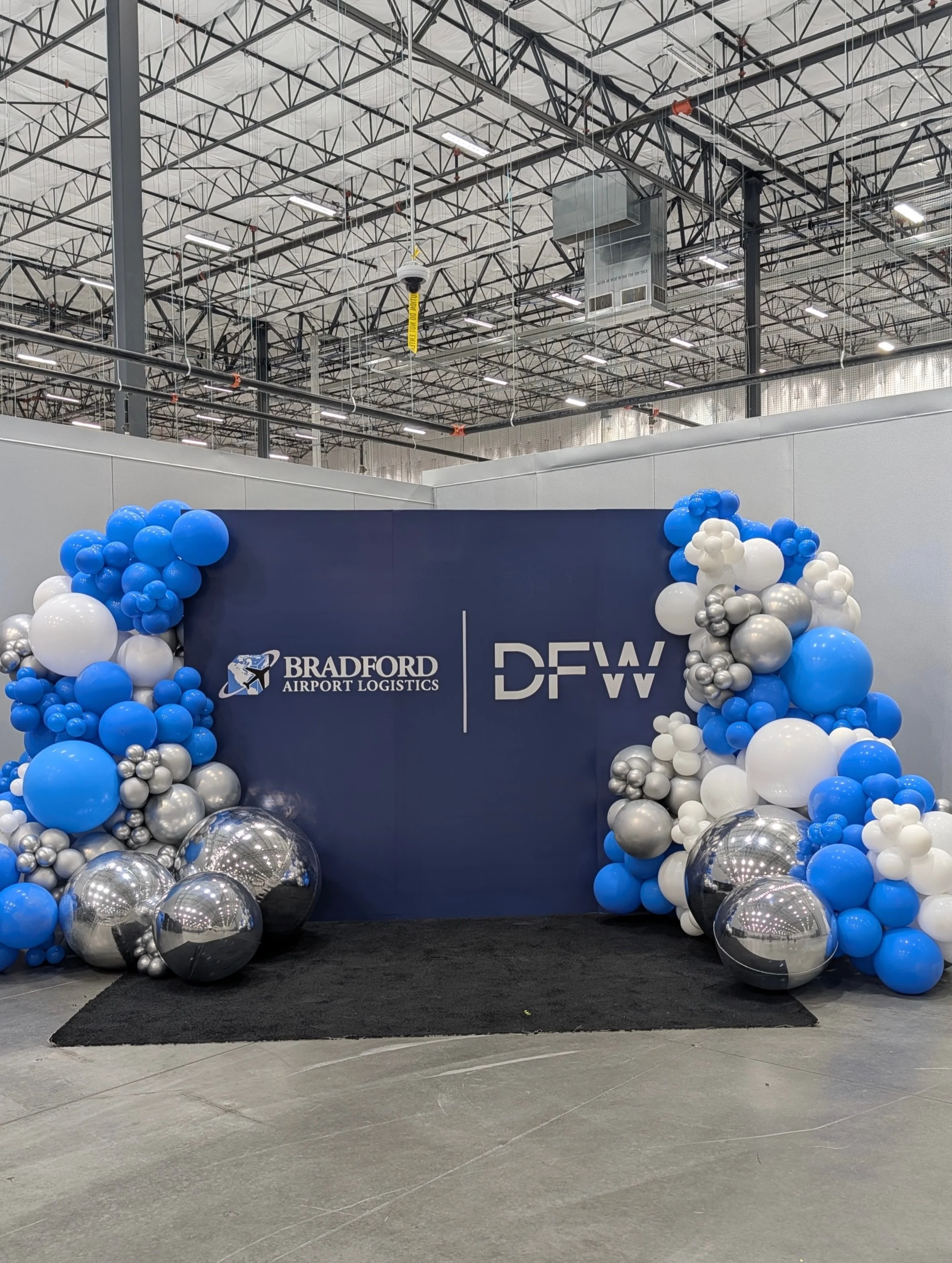 Big space = big impact. ✨

For this new DFW facility opening, the d&eacute;cor needed enough scale to stand out in a massive warehouse. We paired a custom 8&rsquo; x 10&rsquo; branded backdrop with oversized balloon installations and large reflective