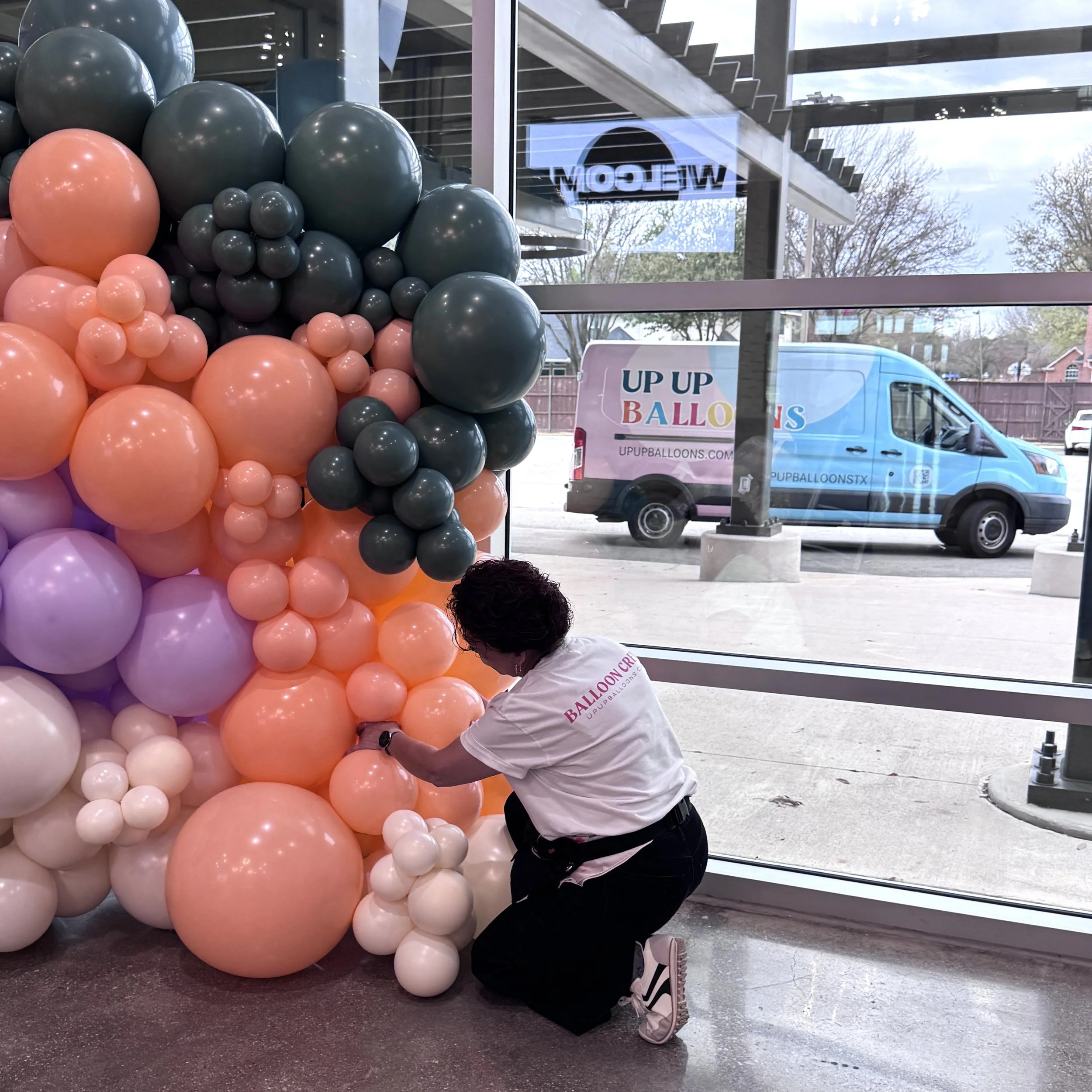 Up Up Balloons team installing organic balloon garland for event in Dallas Fort Worth