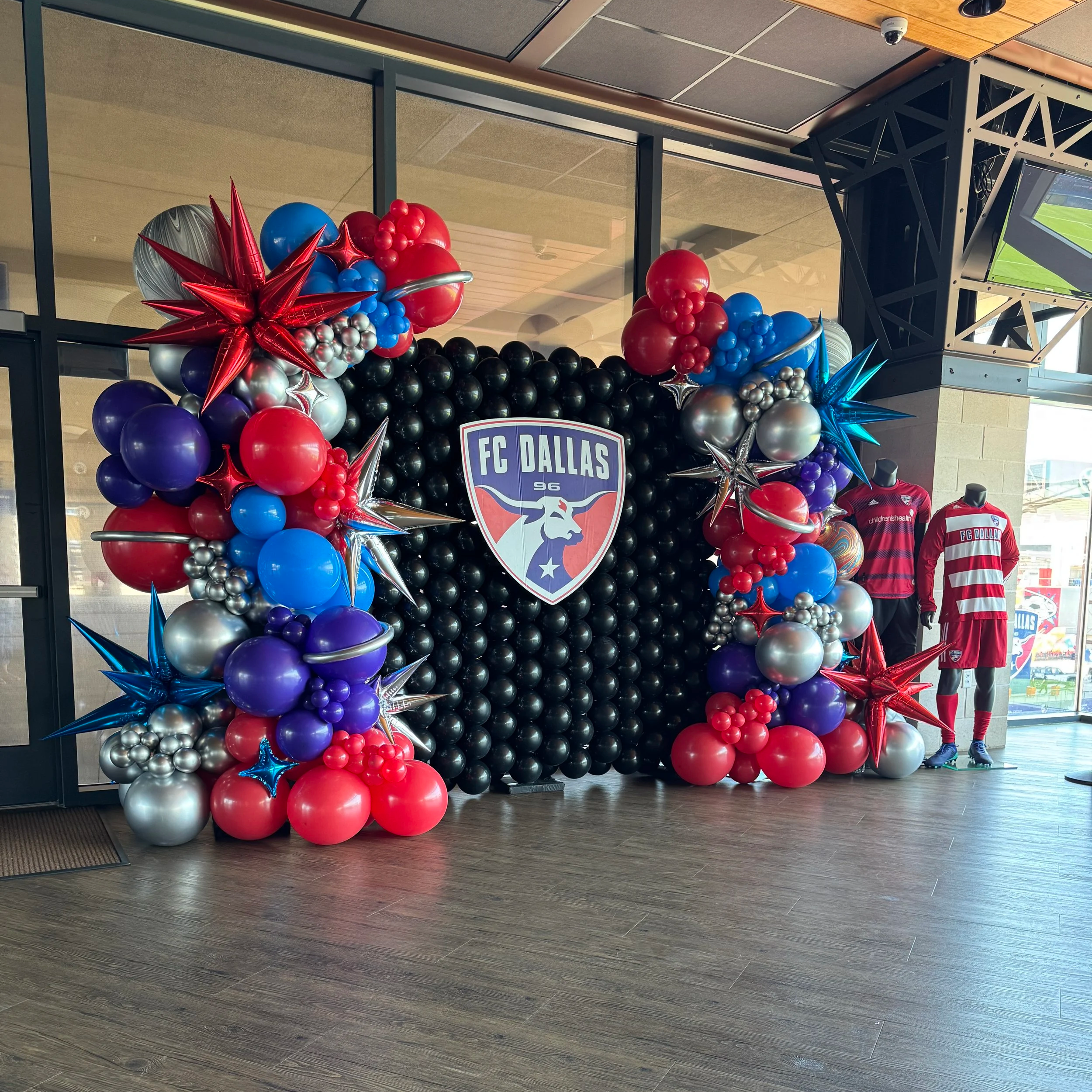 Custom corporate balloon wall with corporate branding for a photo backdrop in Frisco at Toyota Stadium.