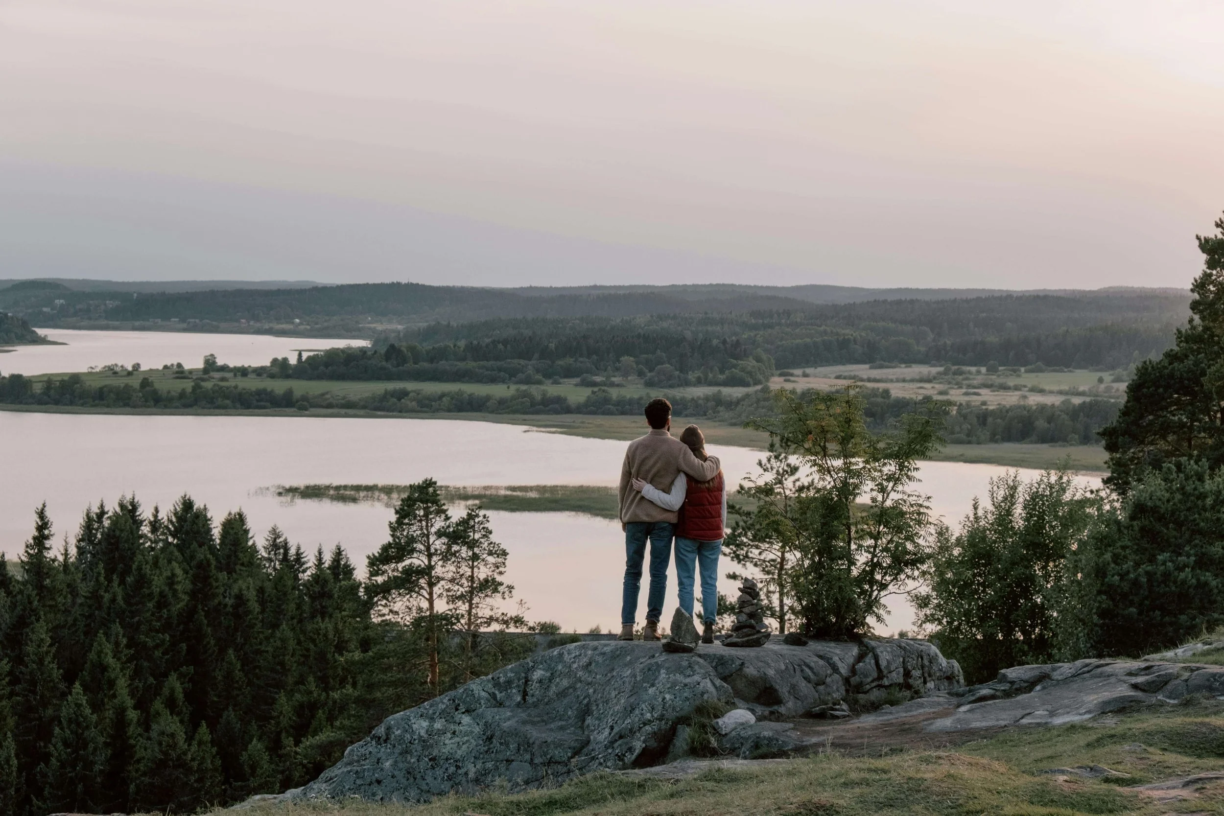 A couple embraces while overlooking a vast lake. Can you find connection again after loss has shaken your world? Online grief counseling in Denver, CO, helps individuals and couples navigate grief together with understanding and care.