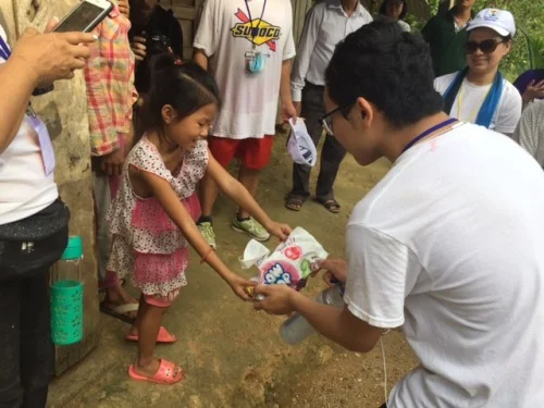 Stephanie’s son, Zak Pham, sharing candy with a local girl. (Photo: Stephanie Nguyen)