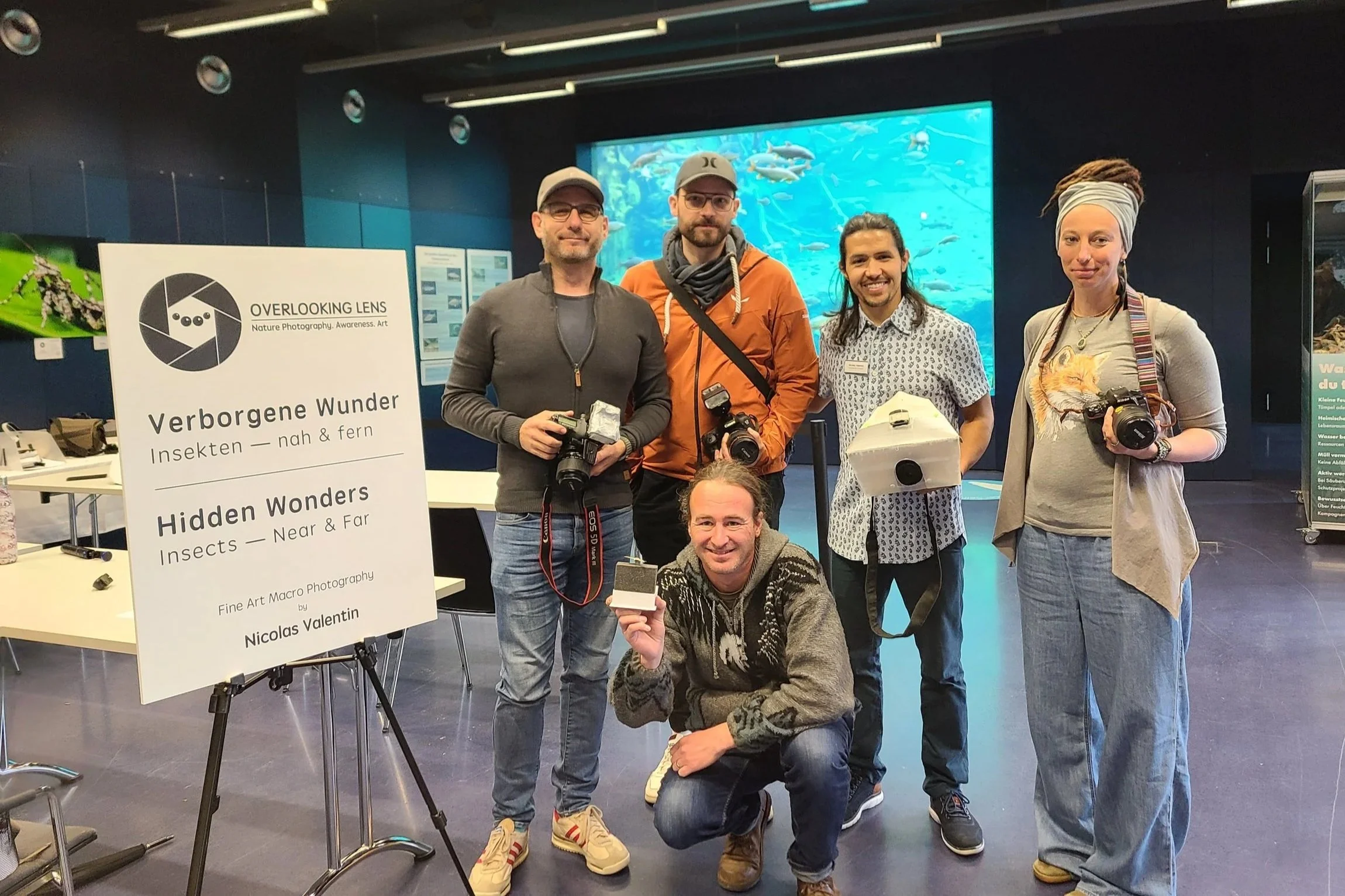 overlooking-lens-workshop-b-group-photo-participants-cameras-specimens-exhibition-sign.jpg