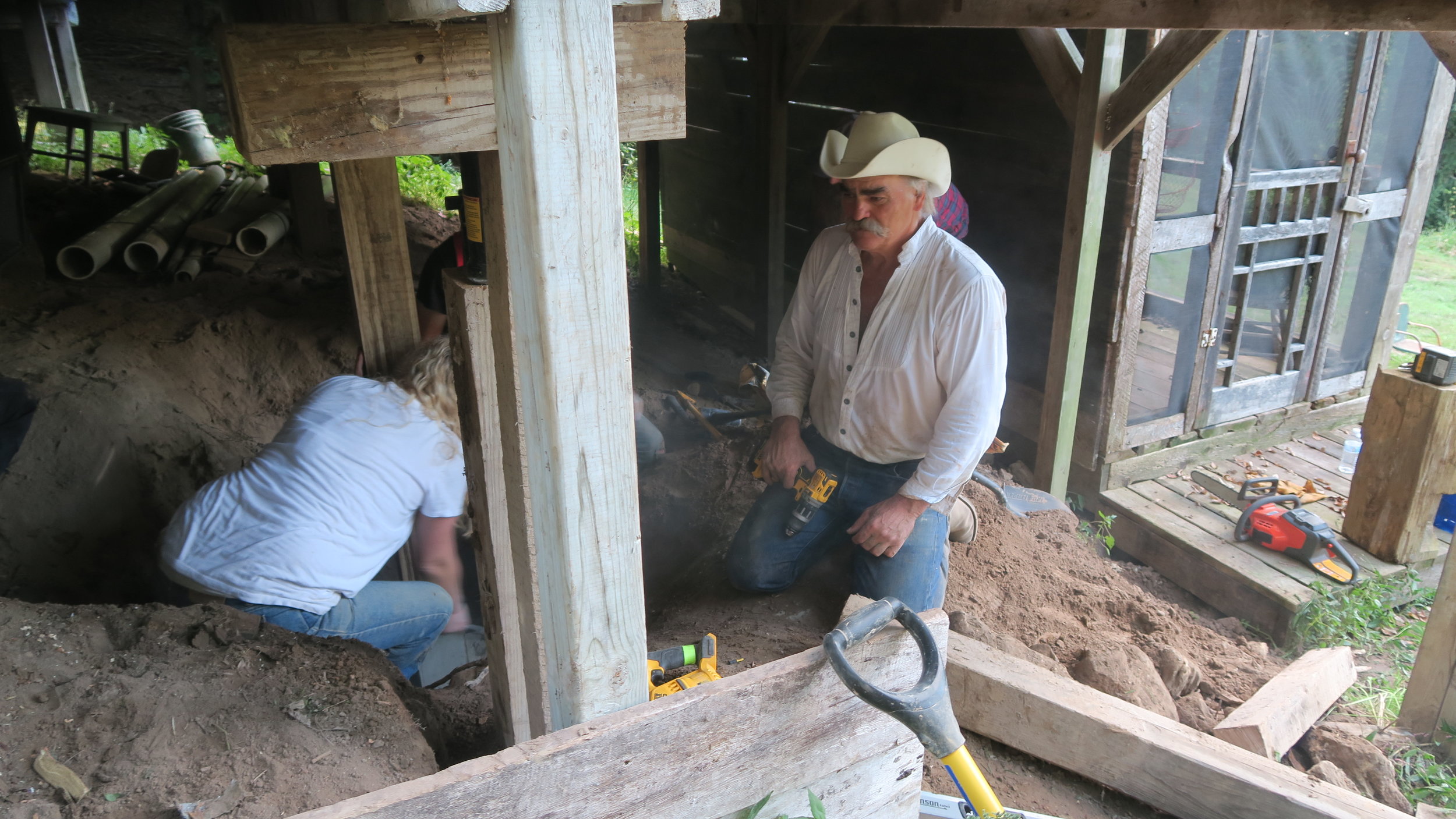  Marty Raney right, helps shore up support beams under the house. Photo by Natalie Munio   