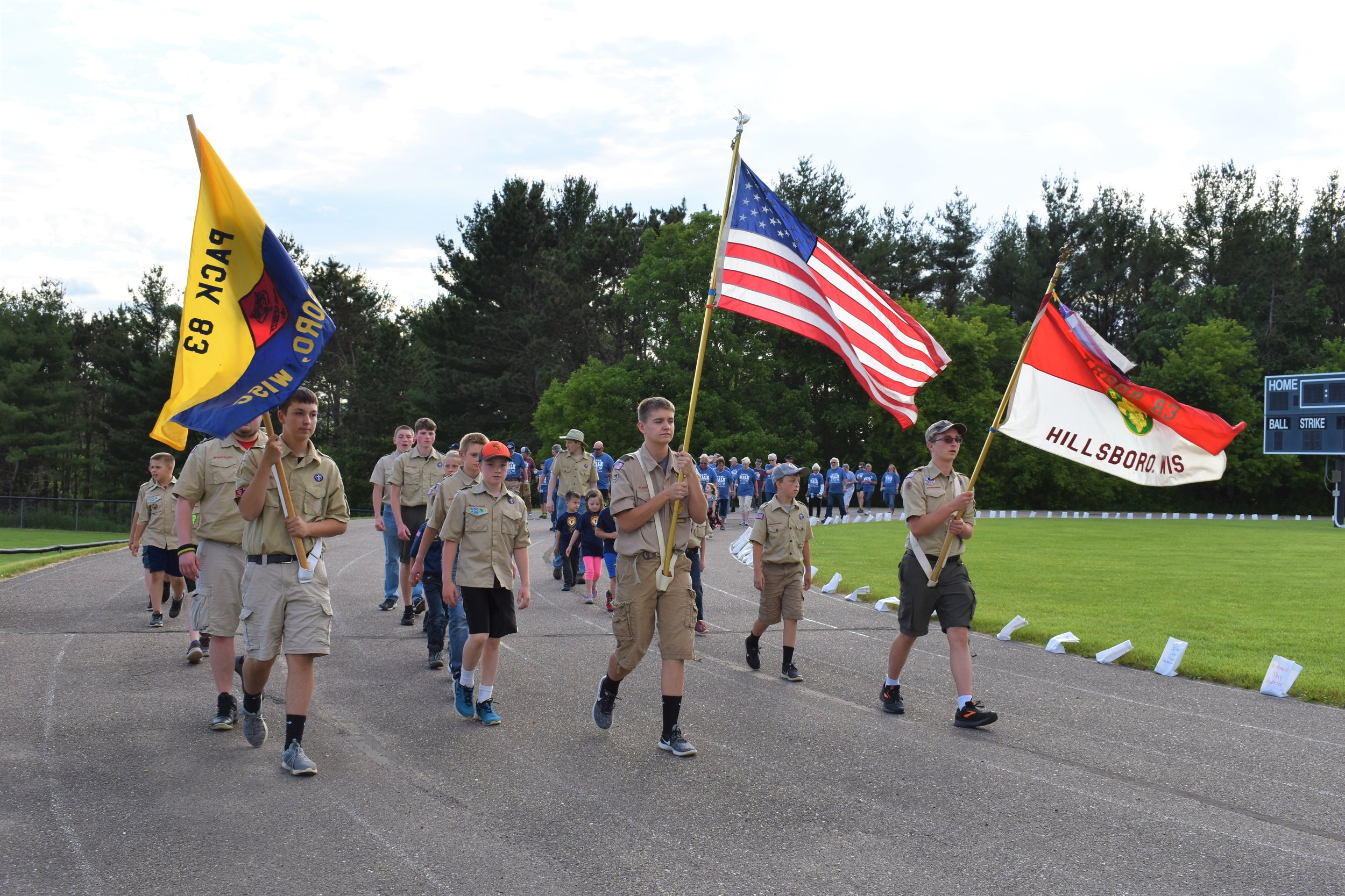  Front l to r- Nathan carrying the Pack 83 flag, Niles carrying the United States flag, and Ethan carrying the Troop 83 flag, lead survivors in opening lap 