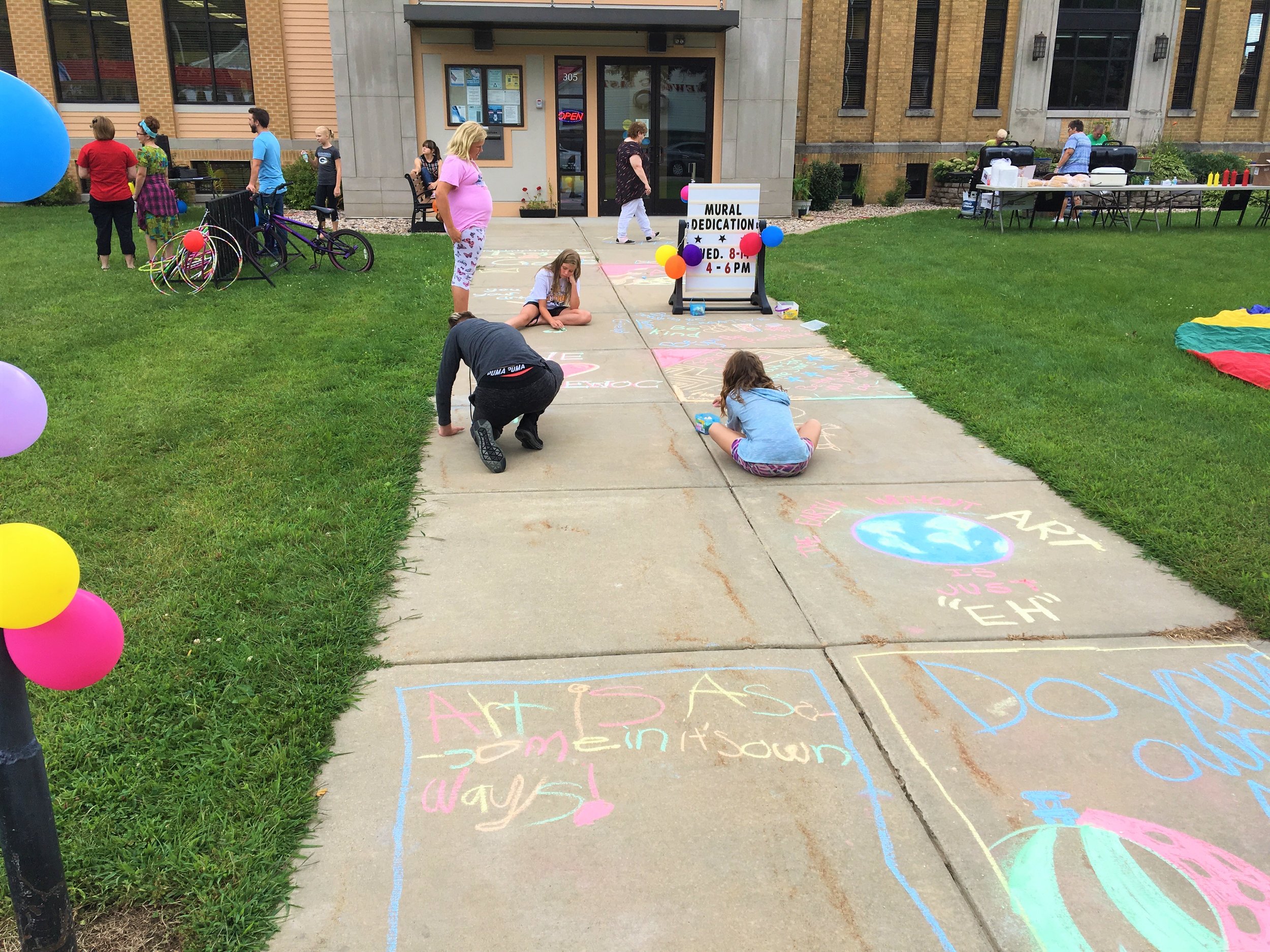  Children create sidewalk art at mural dedication 