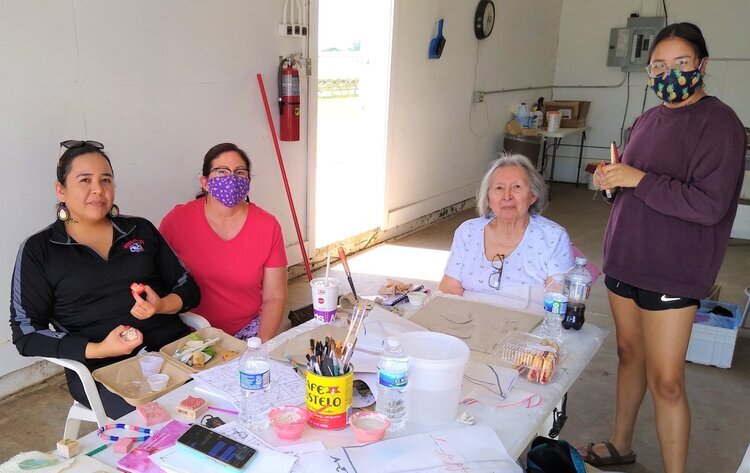  L to r- Laura LaMere, Angie Lowe, Lenore Sweet, and Gysela Ortega work, on a mural for the Maa Wákąčąk portion of the Great Sauk Trail. 