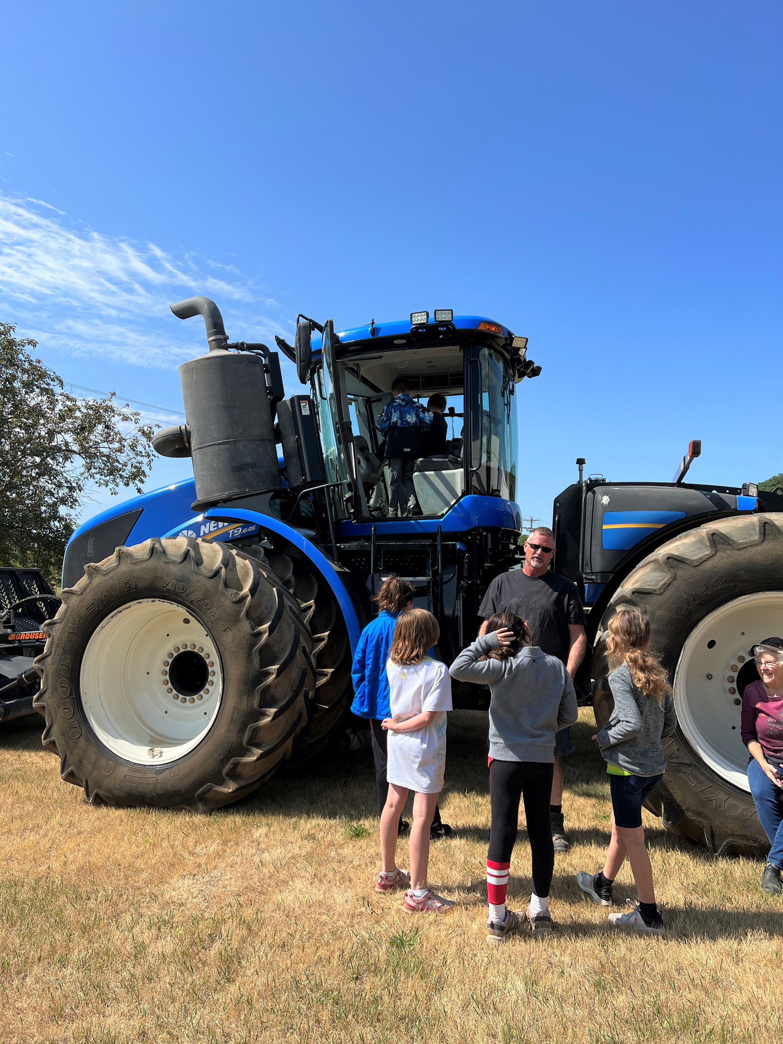  Greg showing one of the tractors to some children attending last years Farm Camp.  Contributed photo  