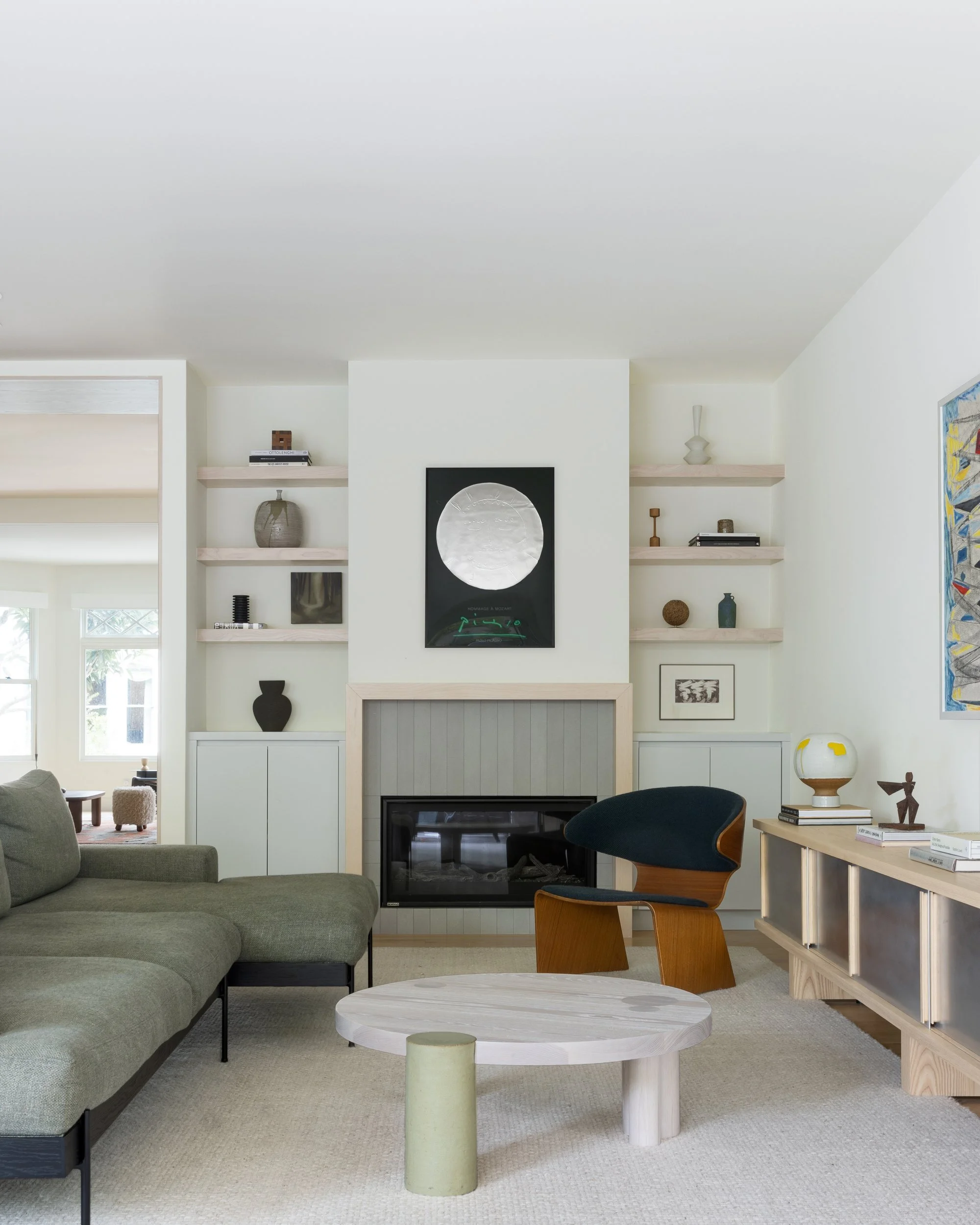Family room with built-in shelves around the fireplace, green sectional and Hinterland coffee table, Cole Valley