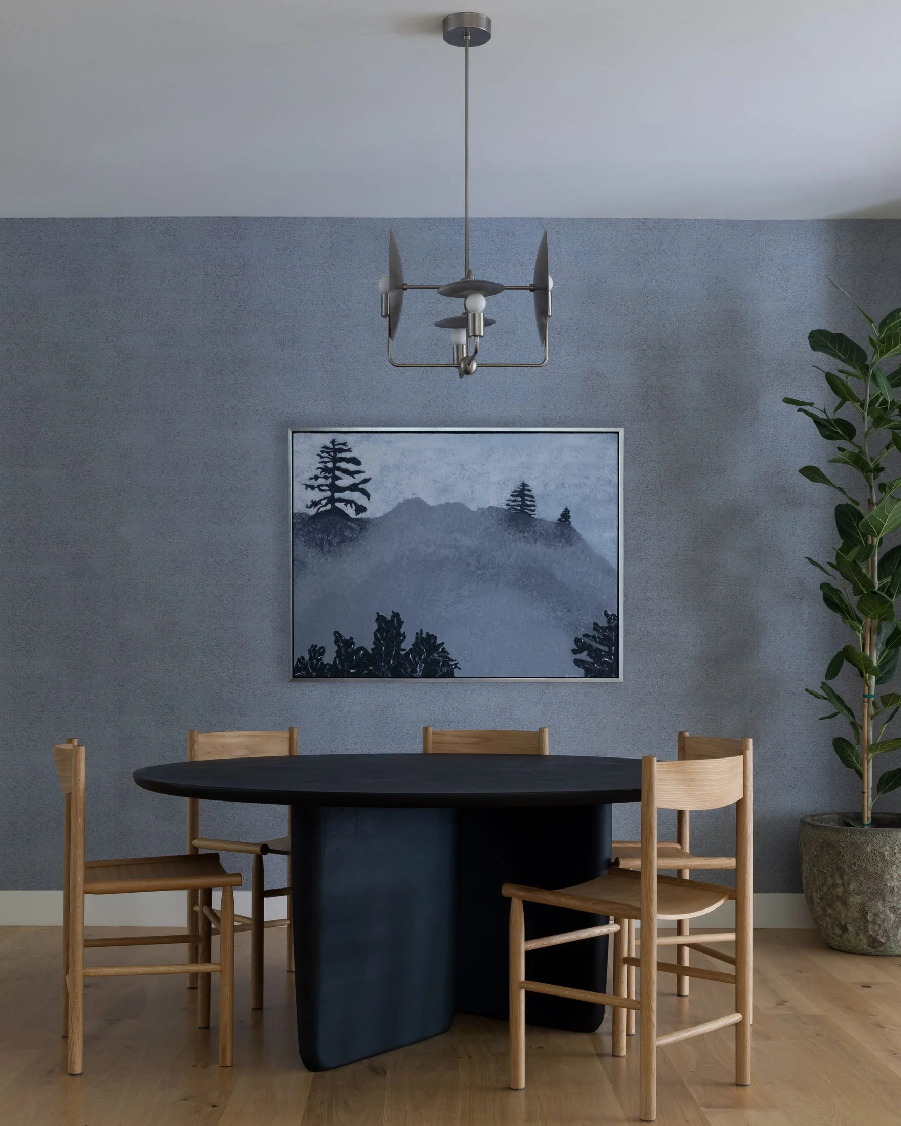 Dining room with Workstead Orbit chandelier, black Tobi-Ishi table and wood chairs against a blue plaster wall, Cole Valley
