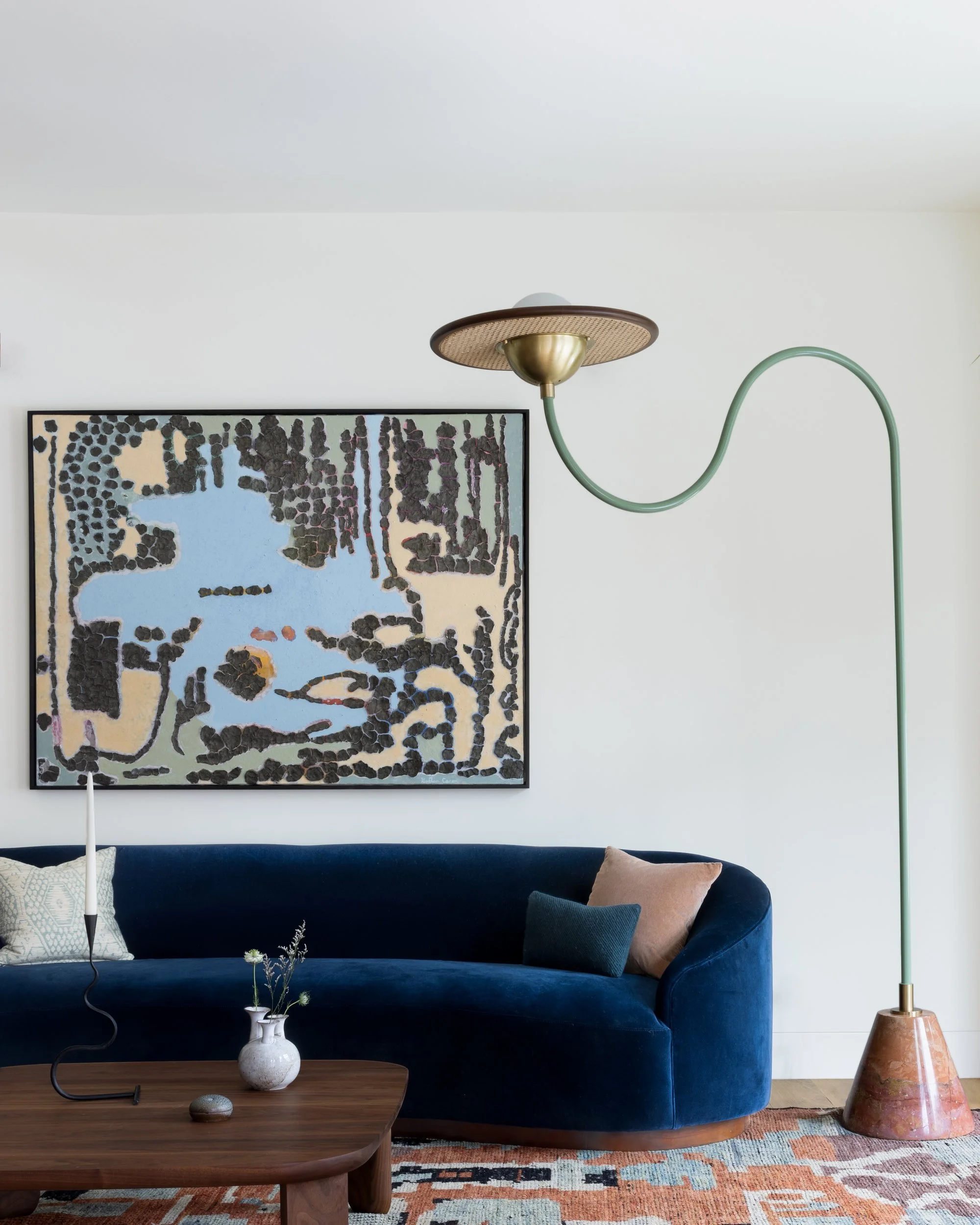 Front parlor with curved navy velvet sofa, arched Cassini floor lamp and a large abstract painting, Cole Valley