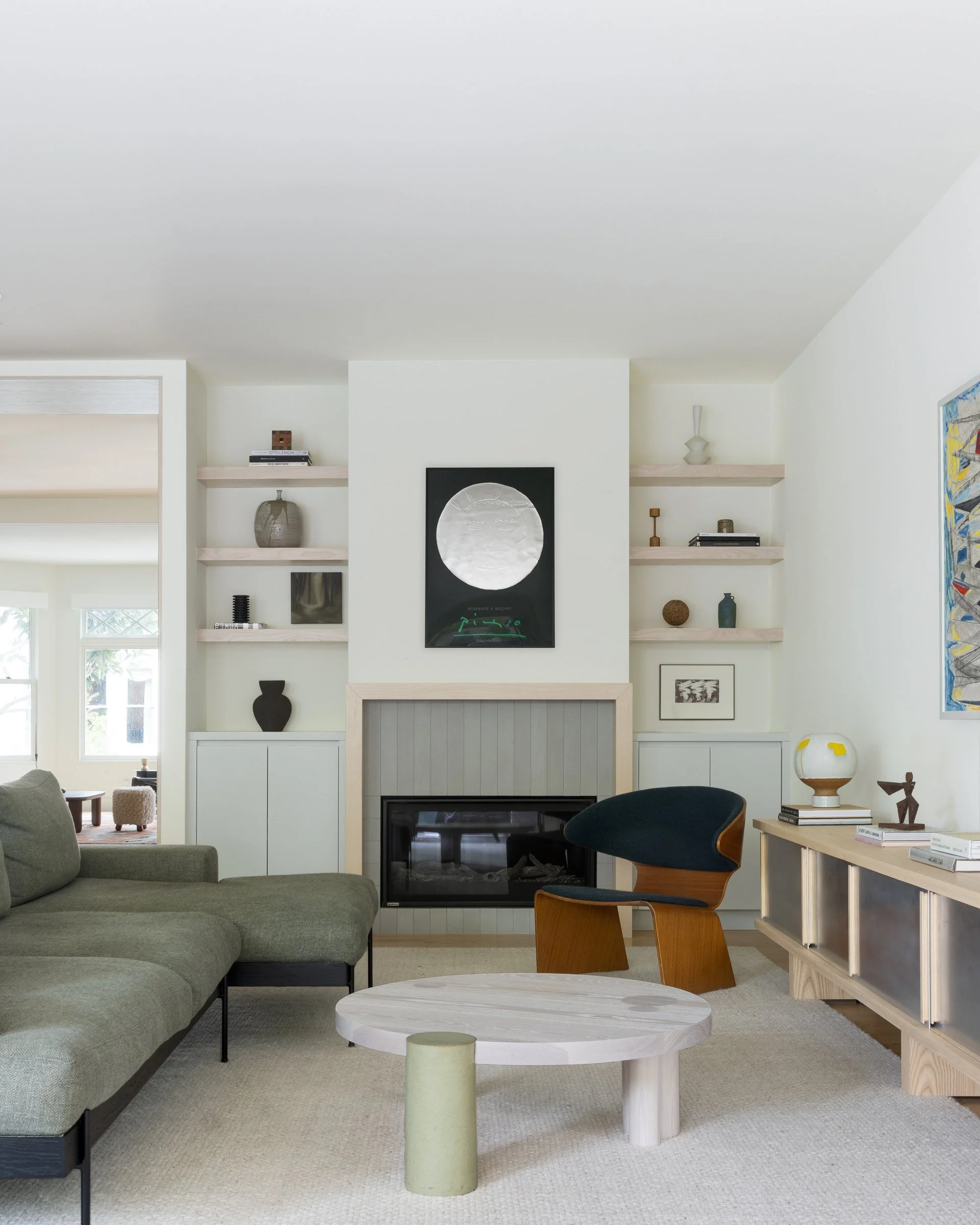 Family room with fireplace, Hinterland's Ecliptic coffee table, a vintage Hans Olsen Bikini chair, and a Croft House sofa in a Cole Valley Edwardian