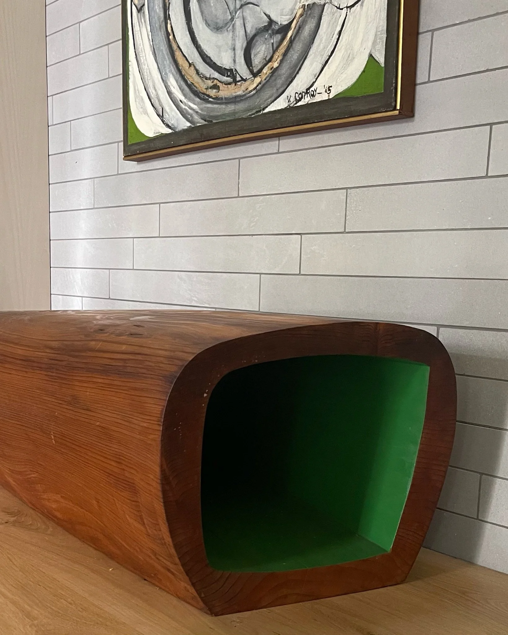 Claude Bouchard's bench, hollowed from reclaimed redwood and painted green inside, beneath a 1965 Virginia Conroy painting