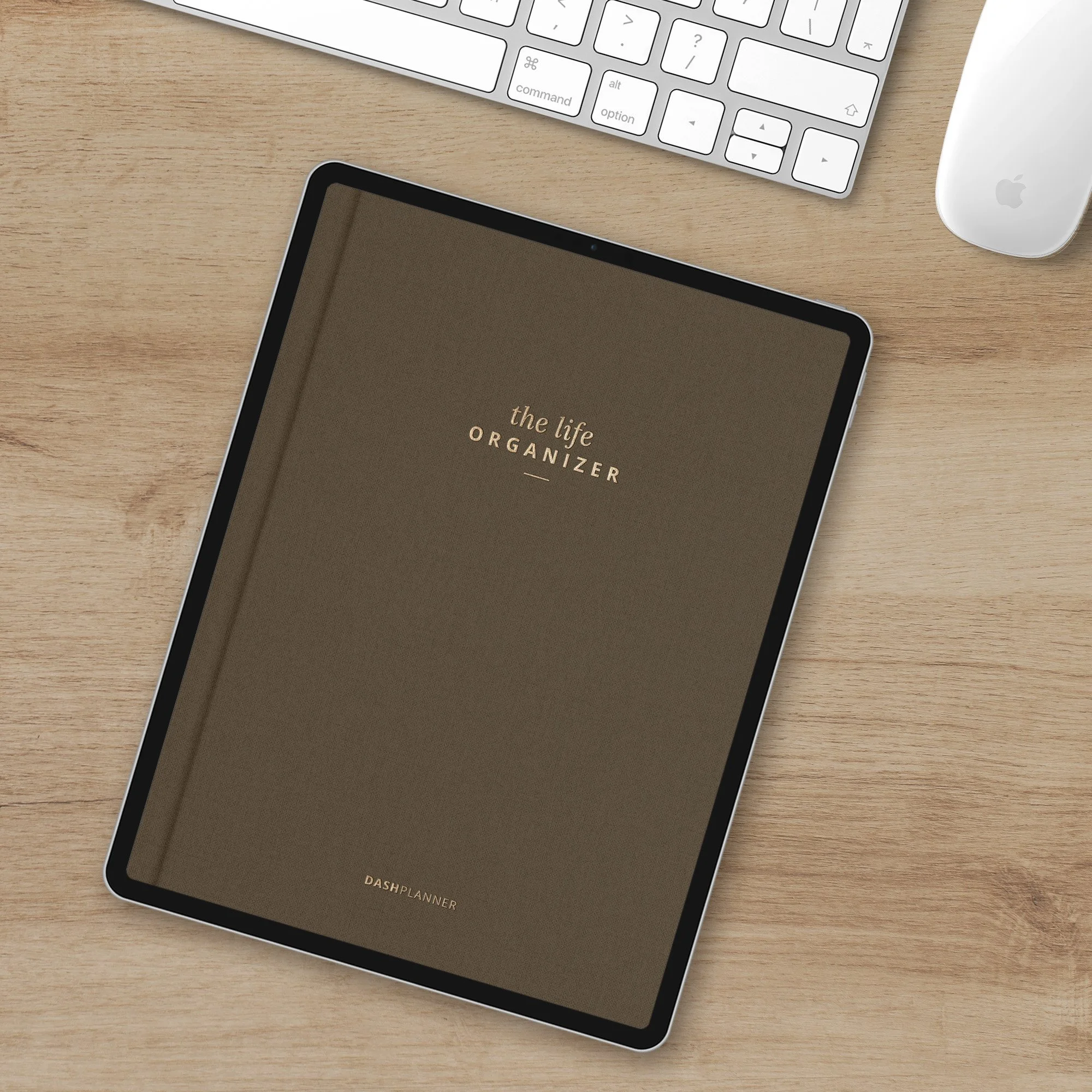 iPad Pro featuring a digital life organizer planner with a linen cover, gold letterpress title on a wooden desk with Mac keyboard and mouse