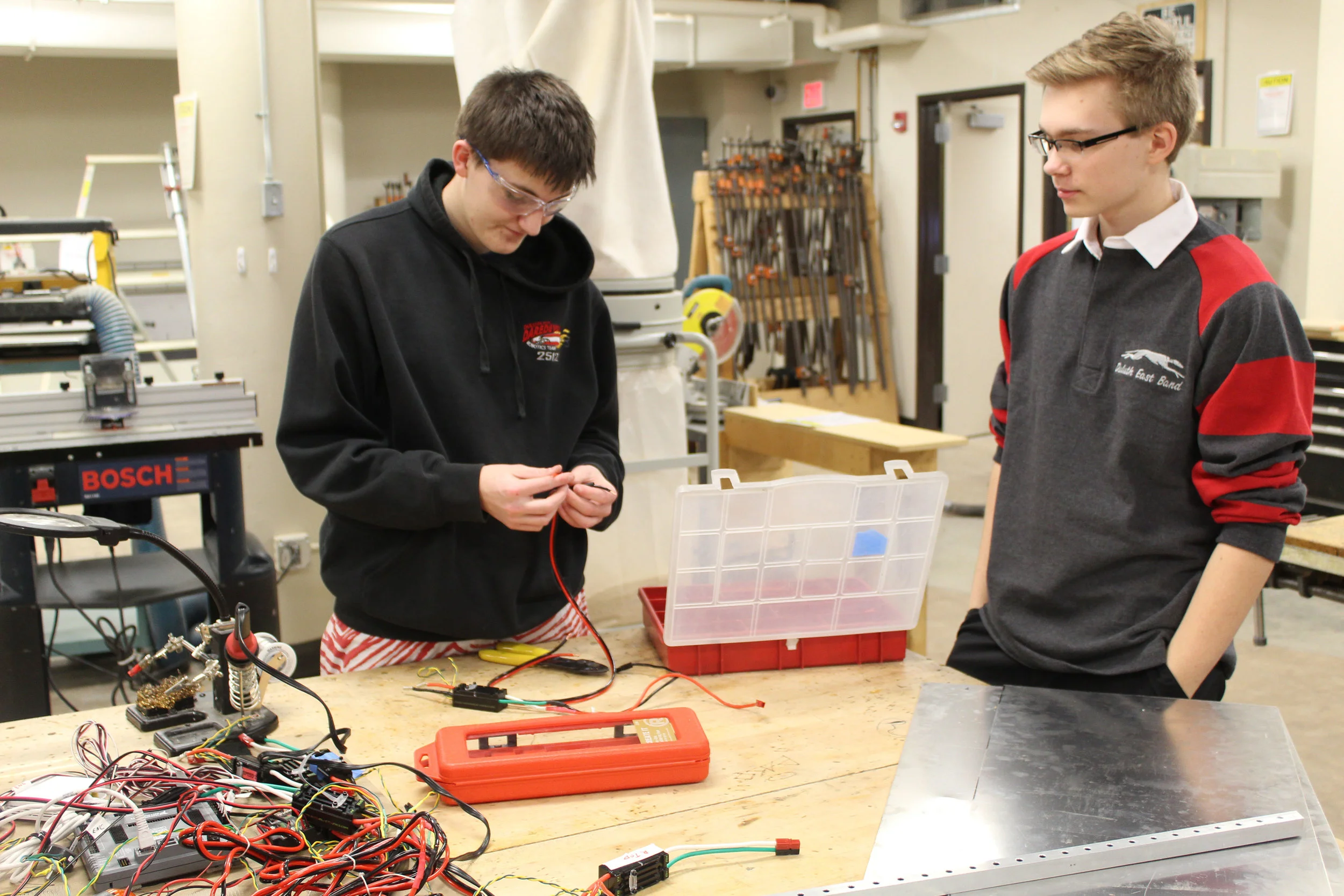 Elliot from Electronics and Spencer from Build splicing wire