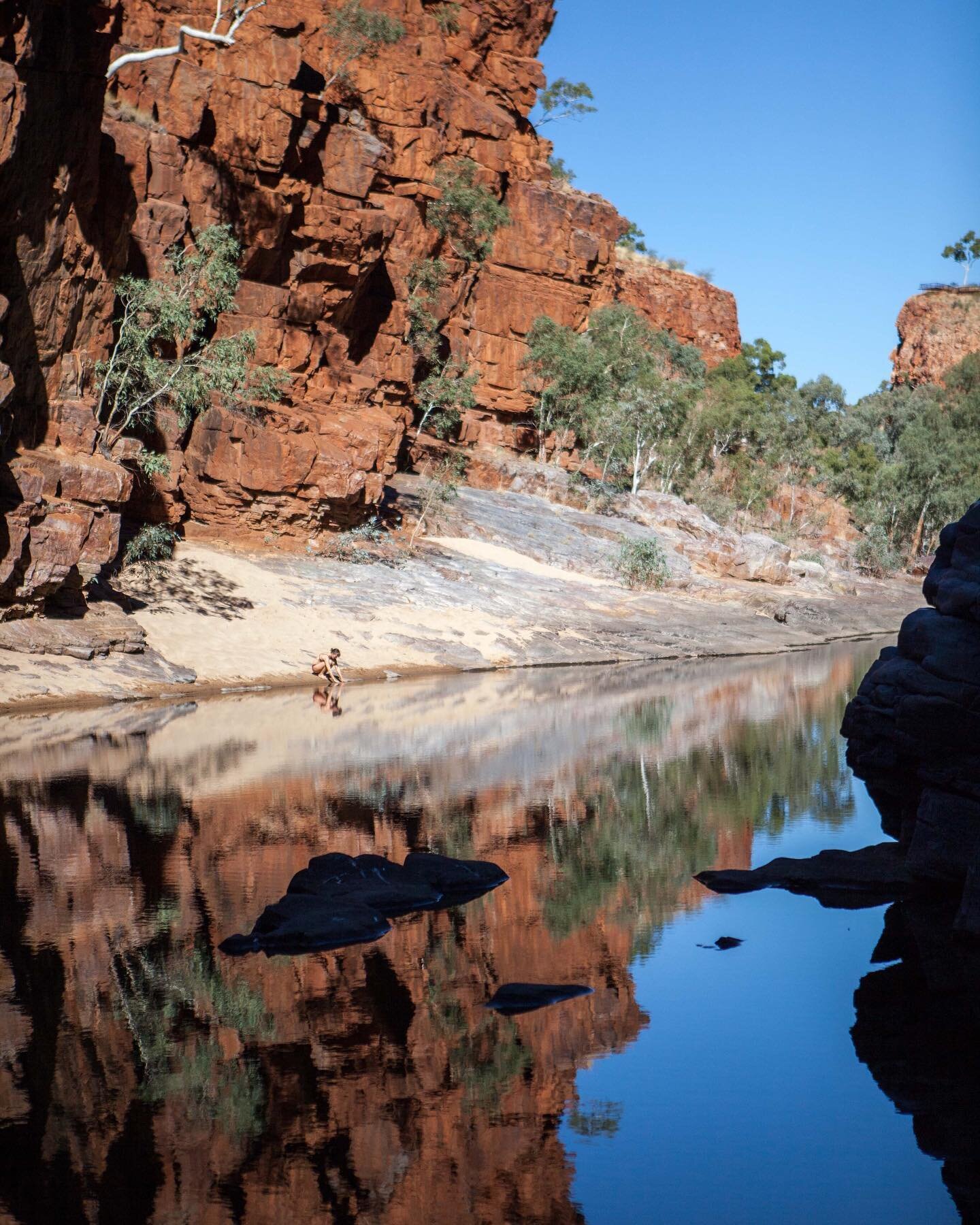 A wintery reflection from Ormiston Gorge, and some of the coldest water we&rsquo;ve ever dipped our toes in. In Central Australia in the West Macdonnell Ranges, these red gorges peel away to reveal blue, cloudless skies. The temperature gets warm in 
