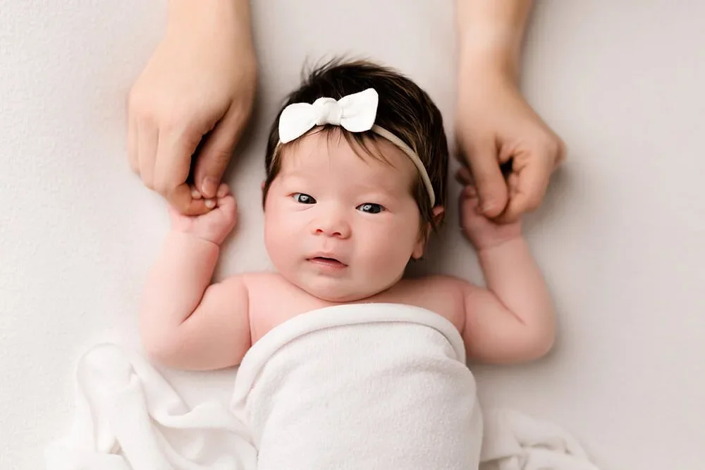 awake baby holding parents hands posing to show ​night doula in bay area