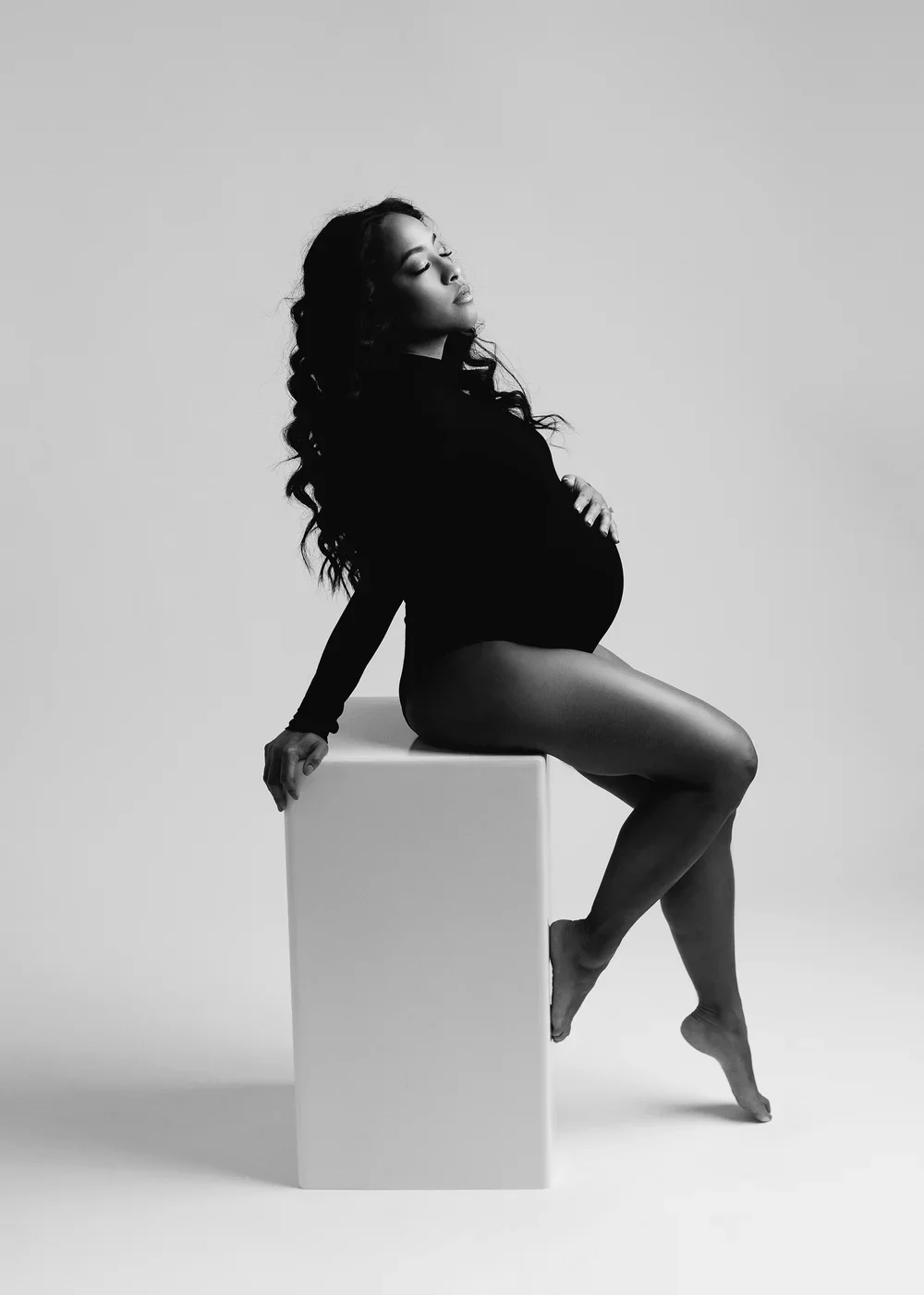 pregnant woman sitting on a white box by bay area maternity photographer