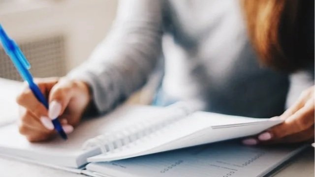 Close-up of a woman writing in a notebook