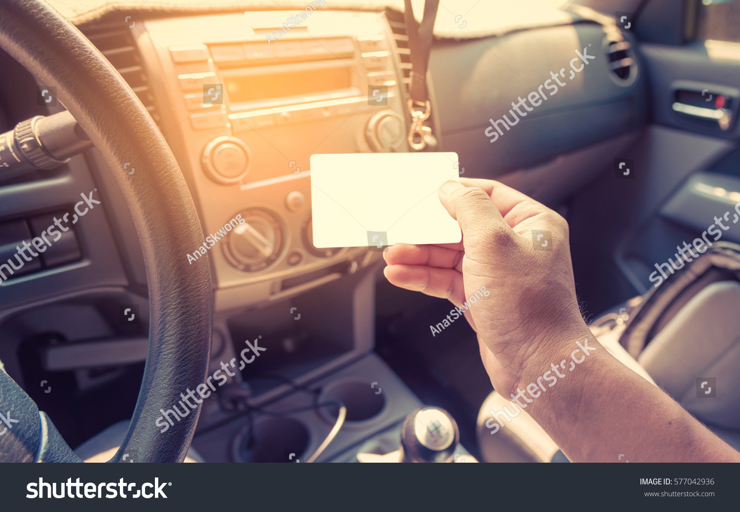stock-photo-driver-in-car-hold-a-blank-business-card-or-driver-license-card-577042936.jpg