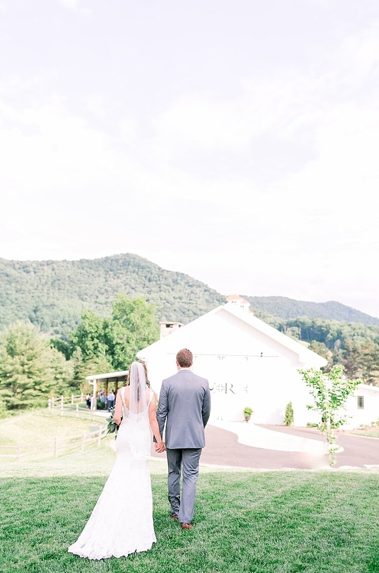 Bride and groom walking towards their mountain wedding venue in North Carolina Chestnut Ridge