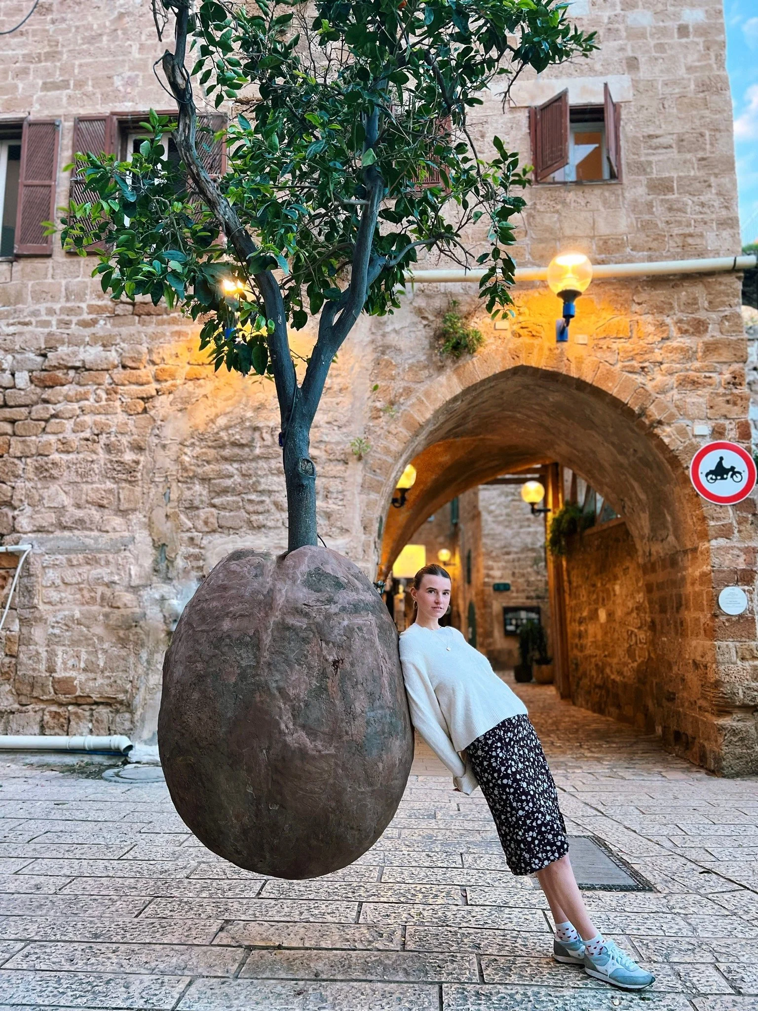 Documentary-style portrait of a woman in a historic stone street, photographed in natural light.