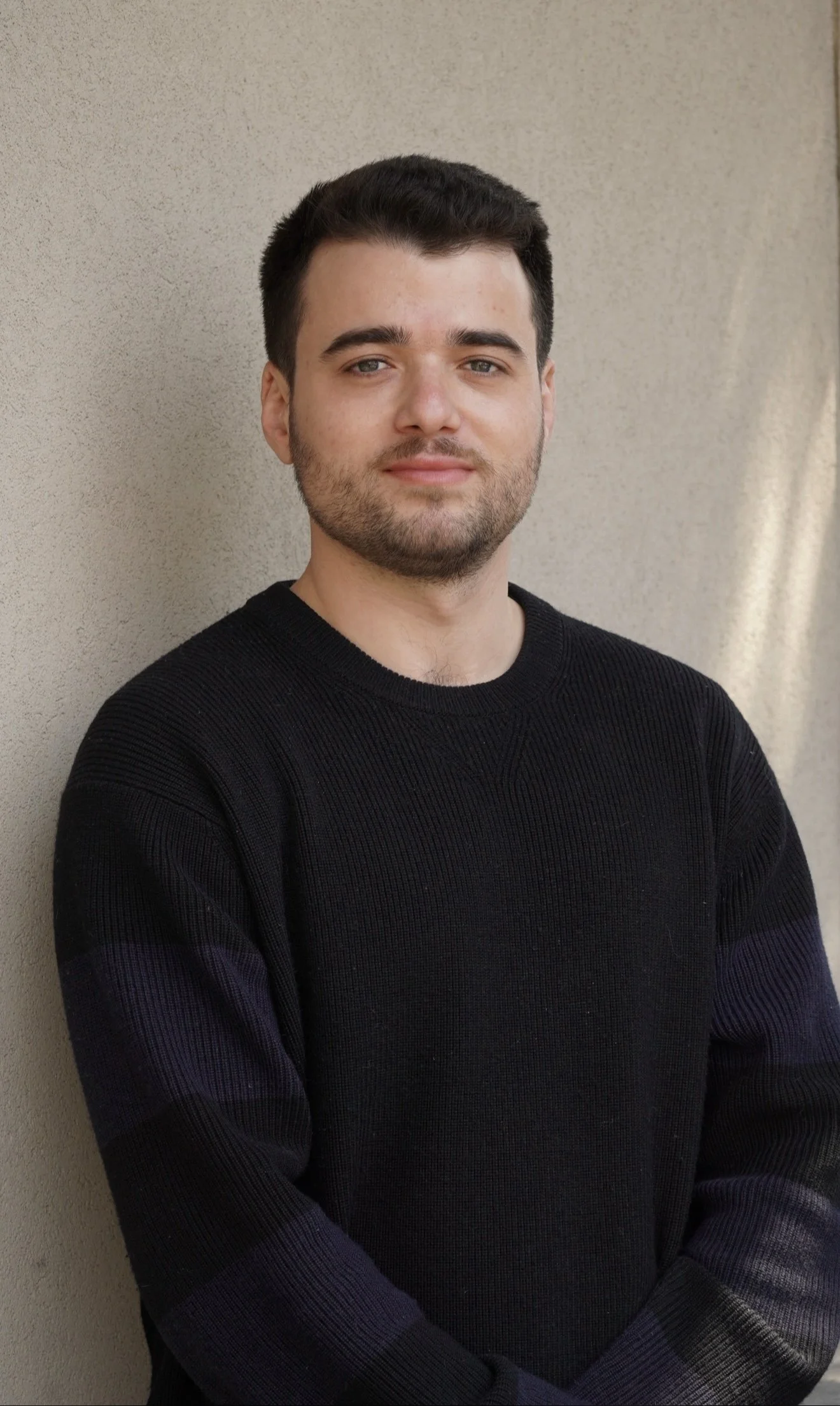 Documentary-style portrait of a man photographed in natural light against a neutral background.