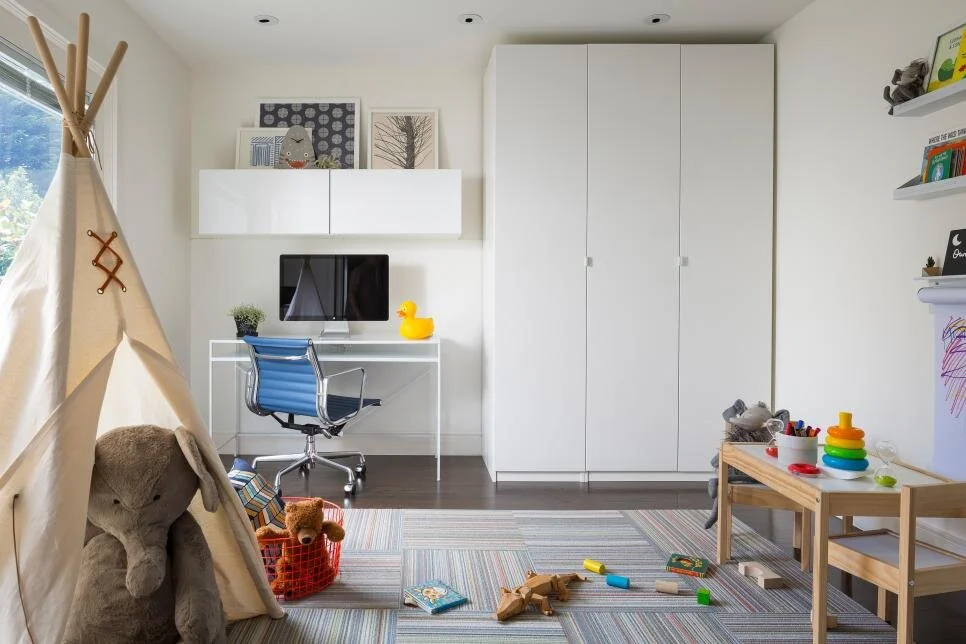 In this office and playroom shared space, an area rug provides a soft place to play while the storage cabinet keeps toys, art supplies and work documents neatly organized.  photo: Scott Hargis