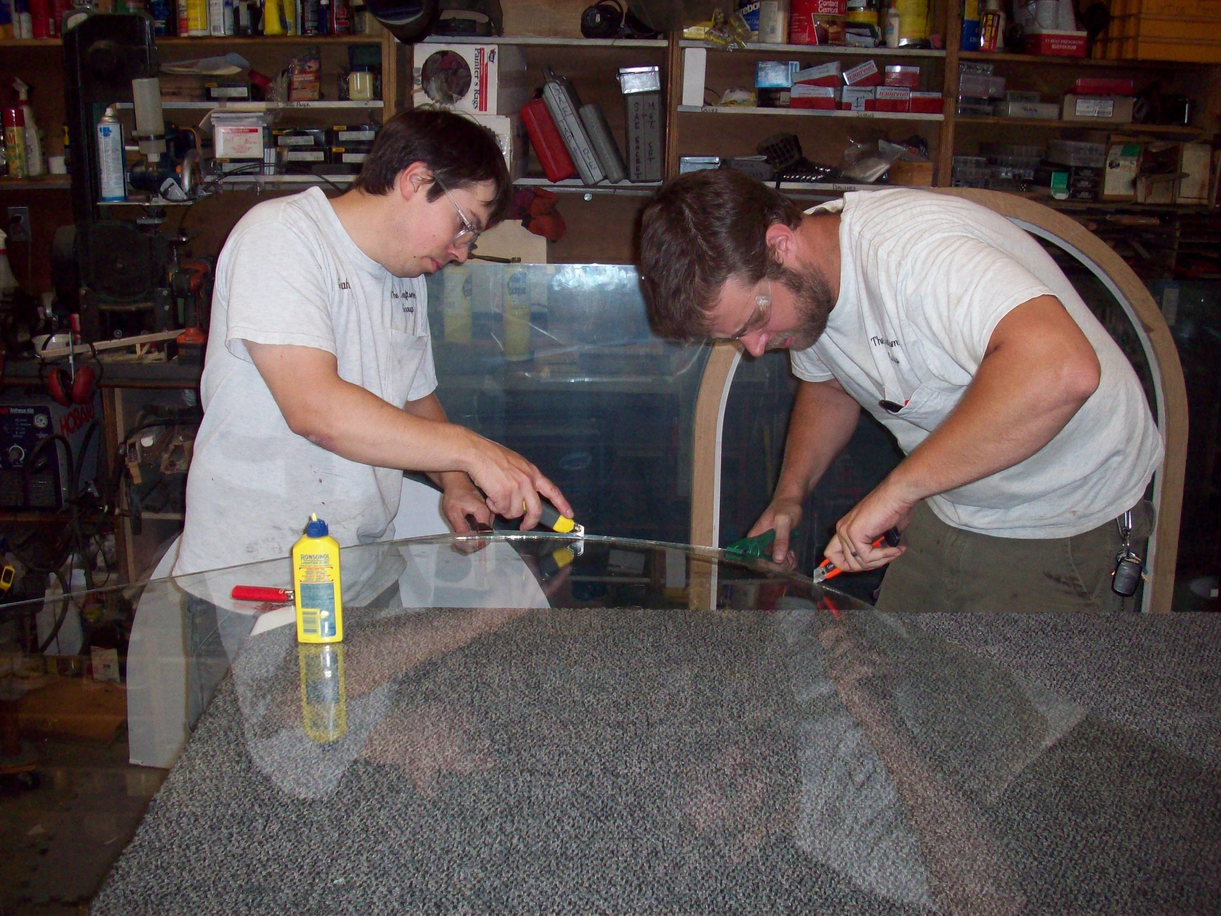 This and the next two photos depict the crucial steps in cutting laminated glass, a material we use more and more since these images from 2008. Laminated glass offers enhanced resistance to sound and thermal transition without the risk that seal failure creates in insulting glass units.