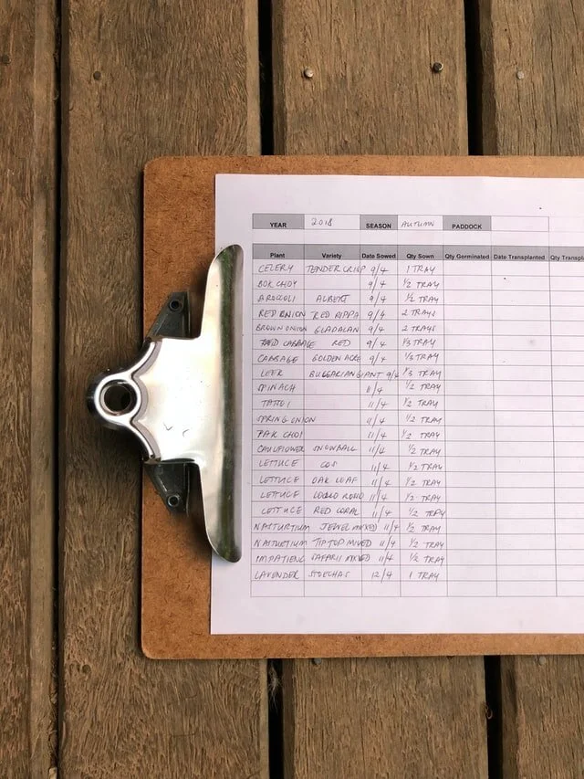 Grower recording moisture readings with paper, pen and clipboard