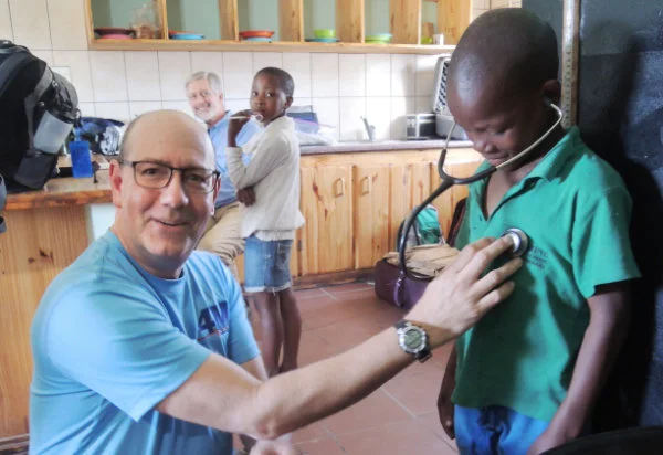 Dr. Rob Zimmerman does basic checkups while Dr. Bob Wenz (background) does eye checks for the children at the St. Camillus Centre.