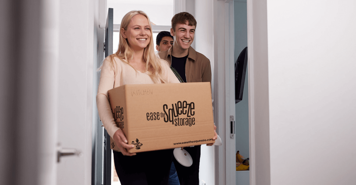 Student carrying a box out of her room