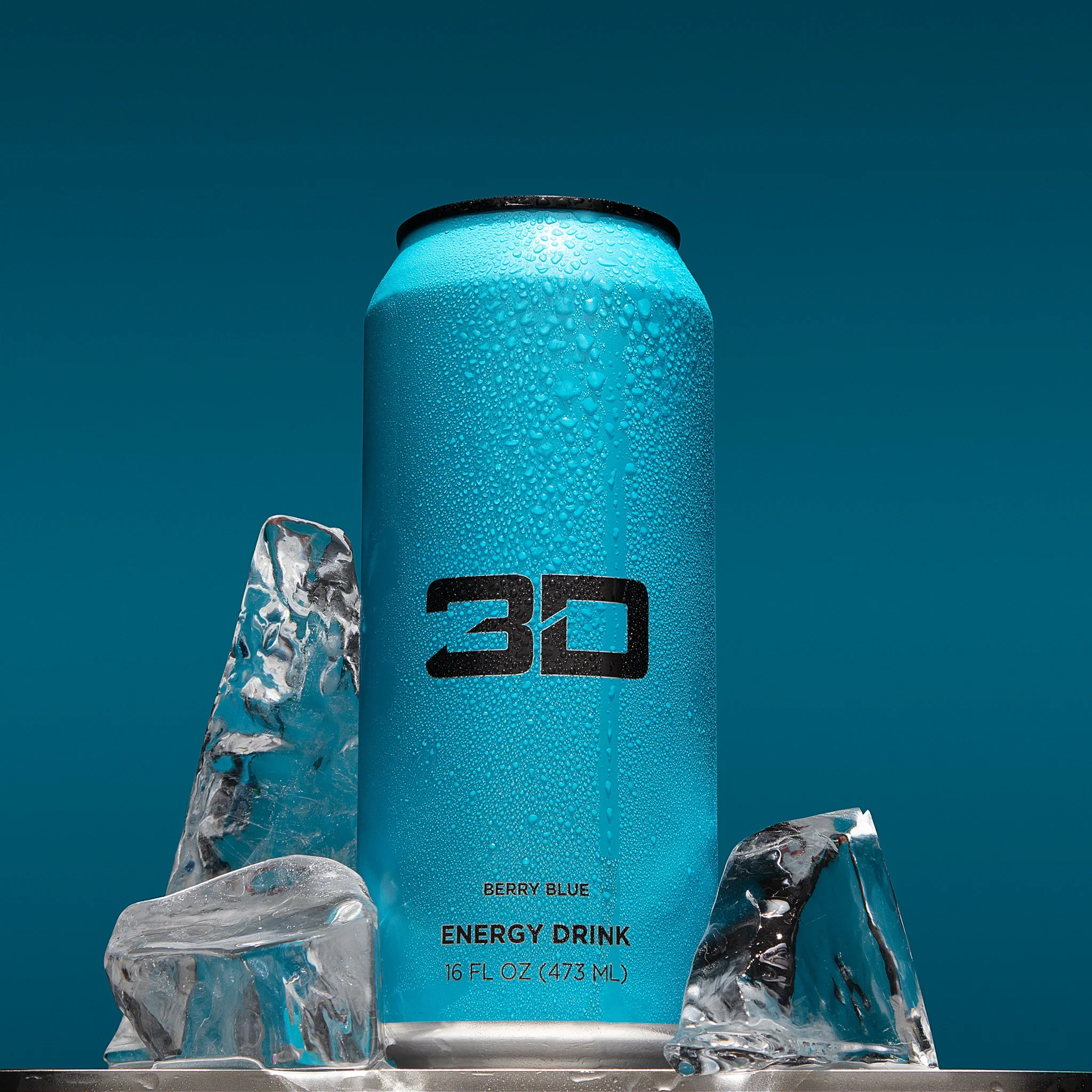 Close-up of a can of Berry Blue Energy Drink with condensation, surrounded by ice cubes, against a teal background.