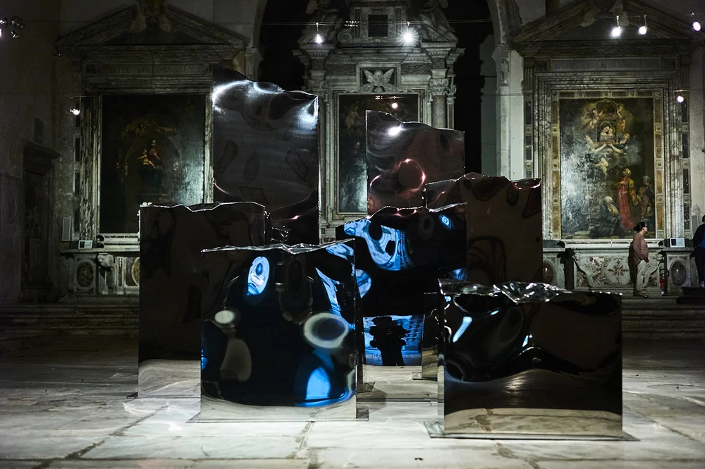 Helidon Xhixha, mirror polished stainless steel sculptures "Pillars of Light" in the church of Pietrasanta as previously exhibited at the 56th Vennice
