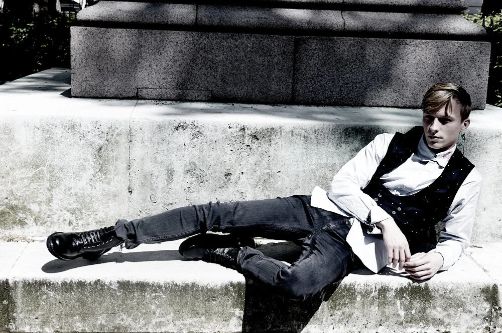 Will Tudor wears shirt by Child of the Jago , waistcoat by Joshua Kane Bespoke , jeans by BLK DNM and boots by Alejandro Ingelmo