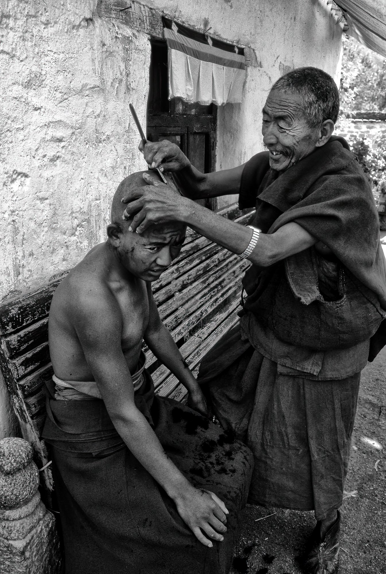 Tibet in a monastery two Tibetan monks shave each other Photo Pierre Toutain-Dorbec.jpg