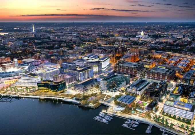Aerial view of Washington, D.C. Halley Rise at dusk, showcasing illuminated buildings and a vibrant skyline against a twilight sky.