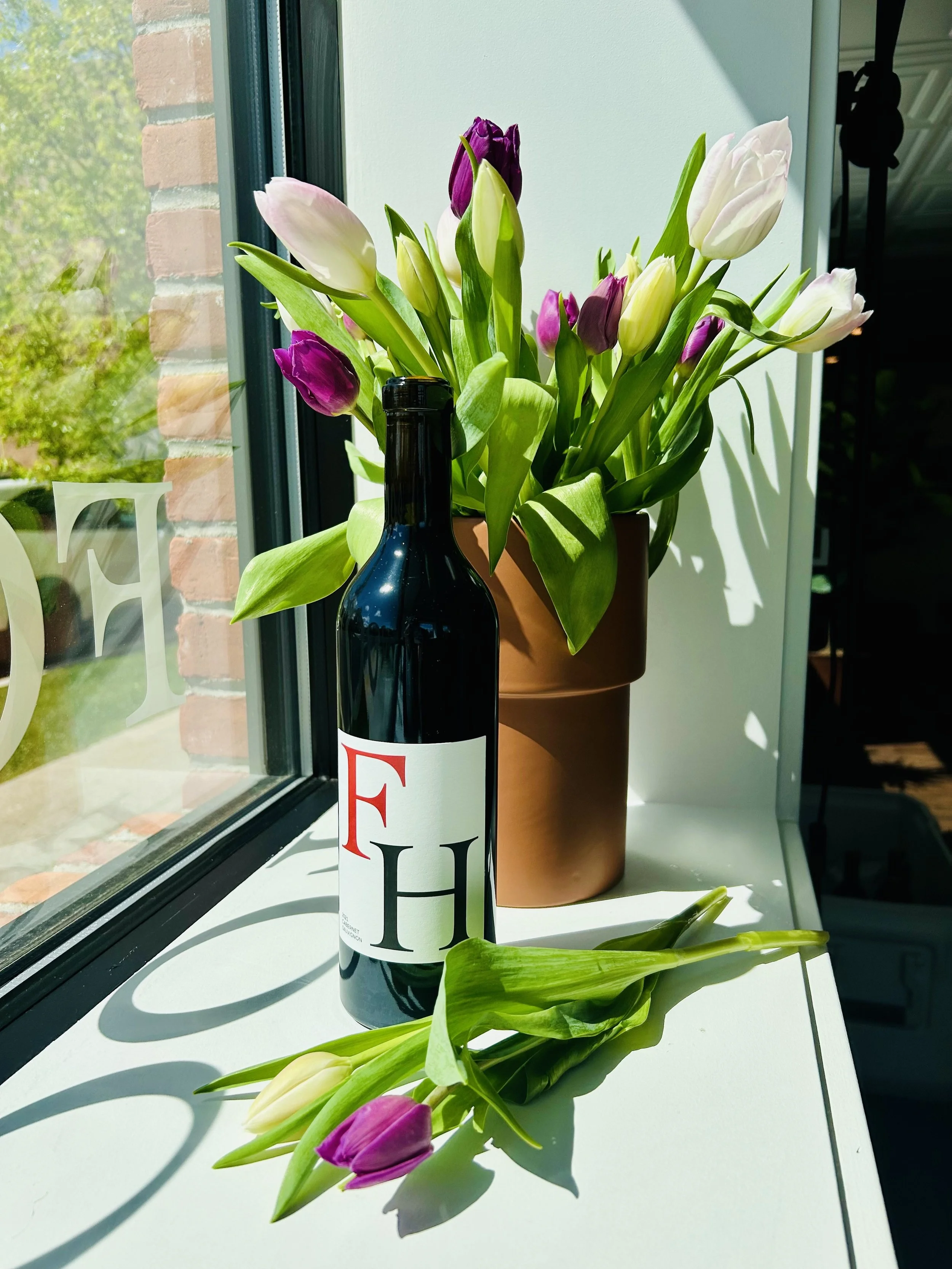 New release FH Cabernet in a sunny window with tulips