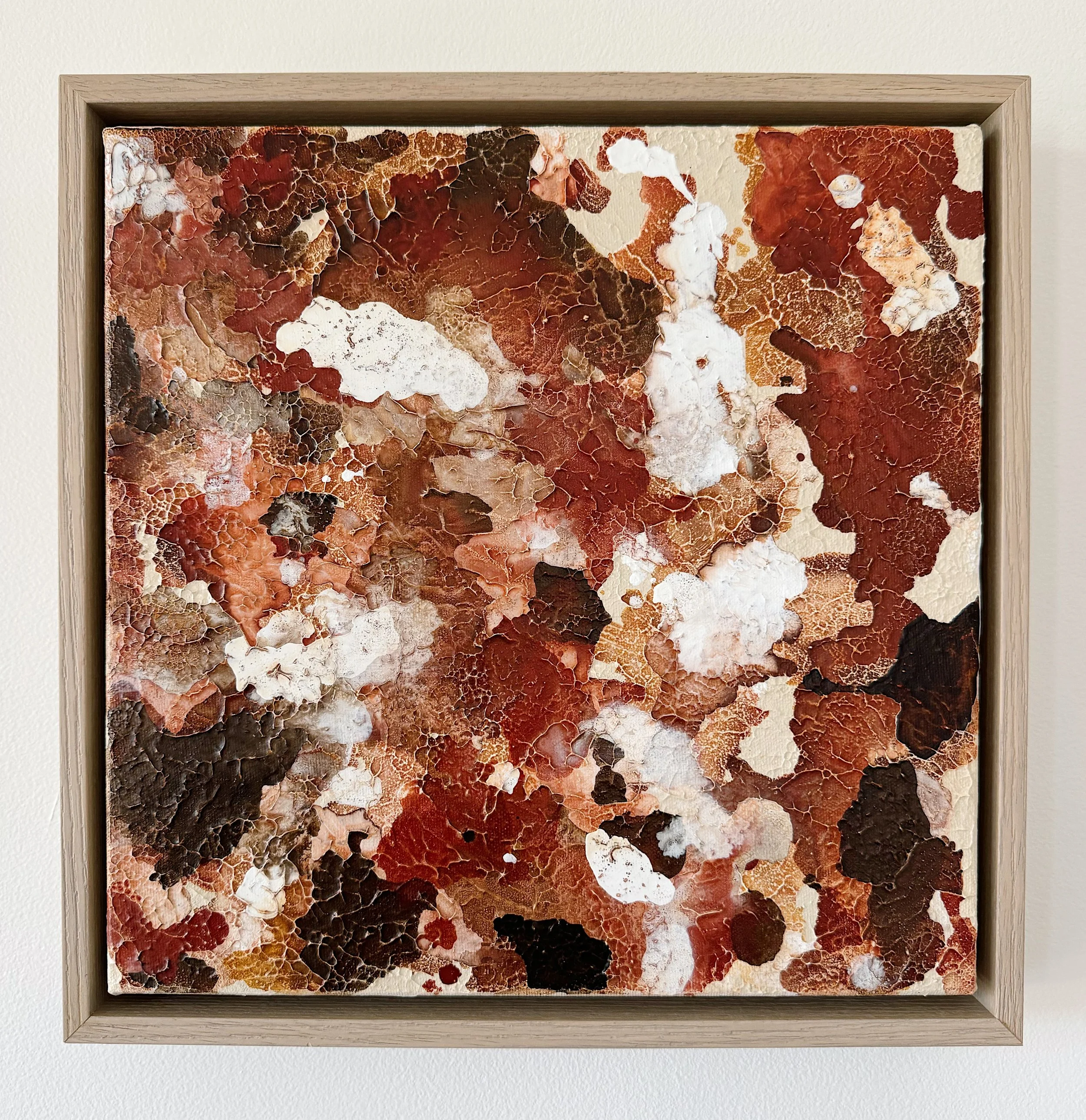 Textured abstract textured painting on canvas with earth tones, including red, brown, black, white, and beige, framed in light wood, inspired by Arizona and Utah desert.
