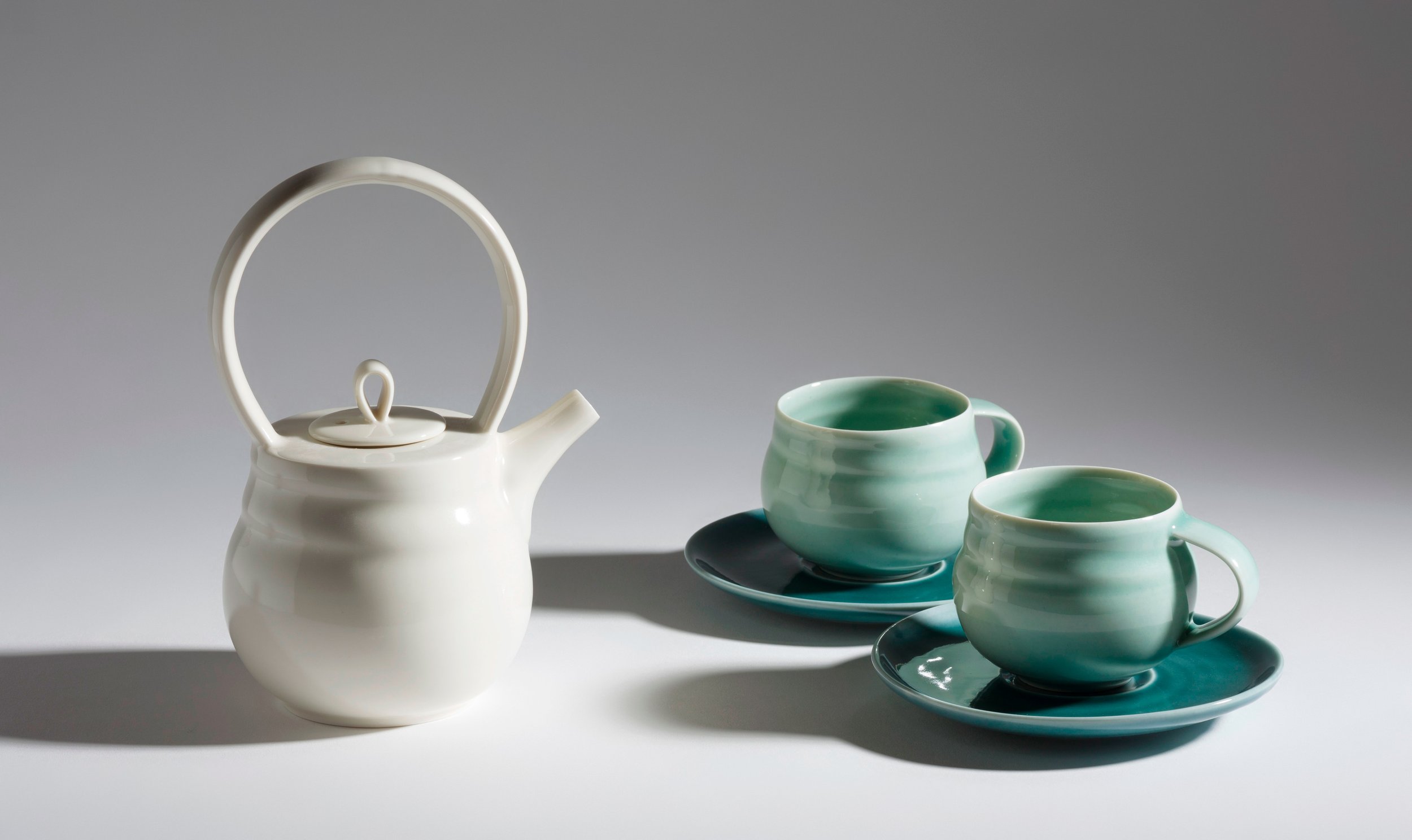 Porcelain teapot with cups and saucers