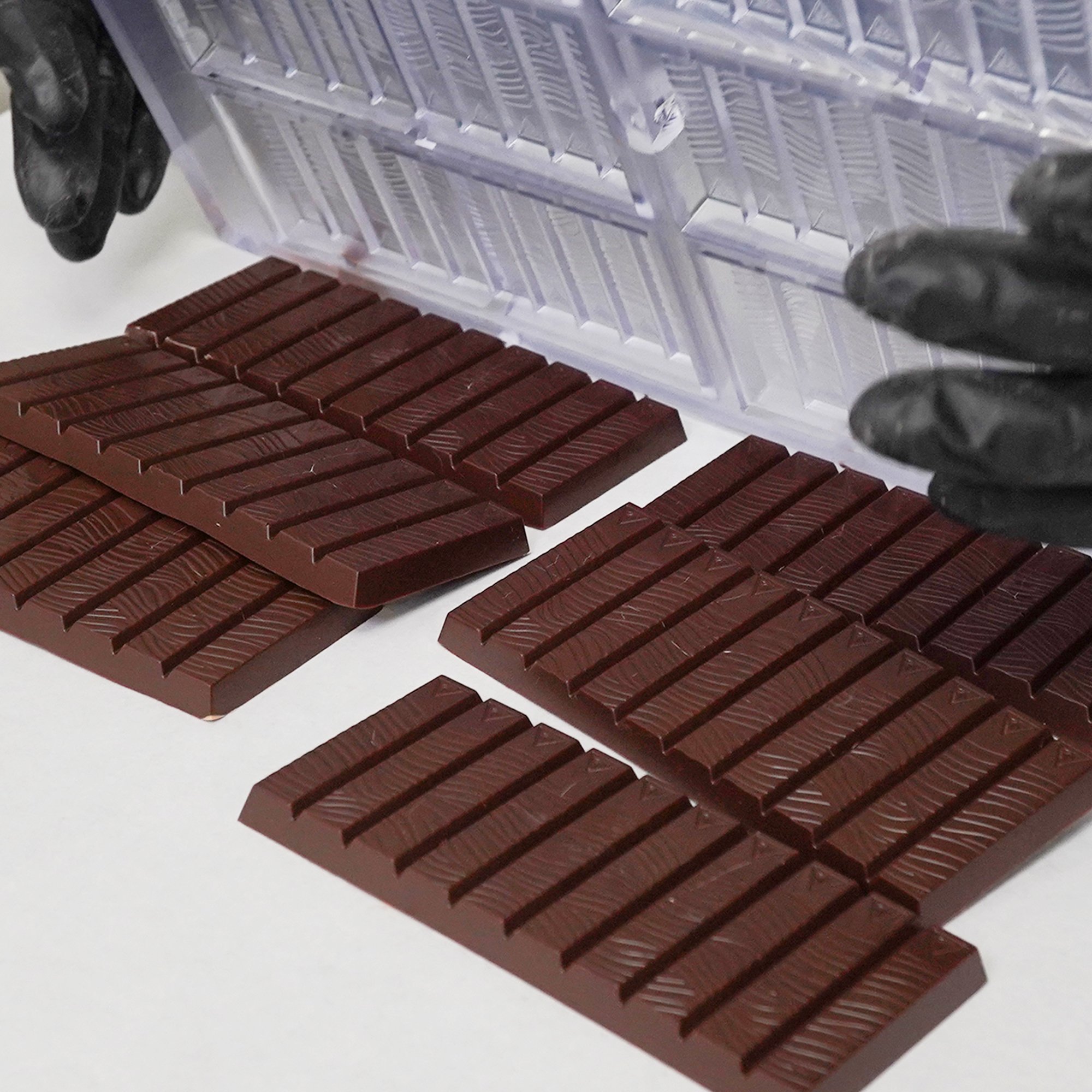 Cooled chocolate bars being removed from chocolate mold