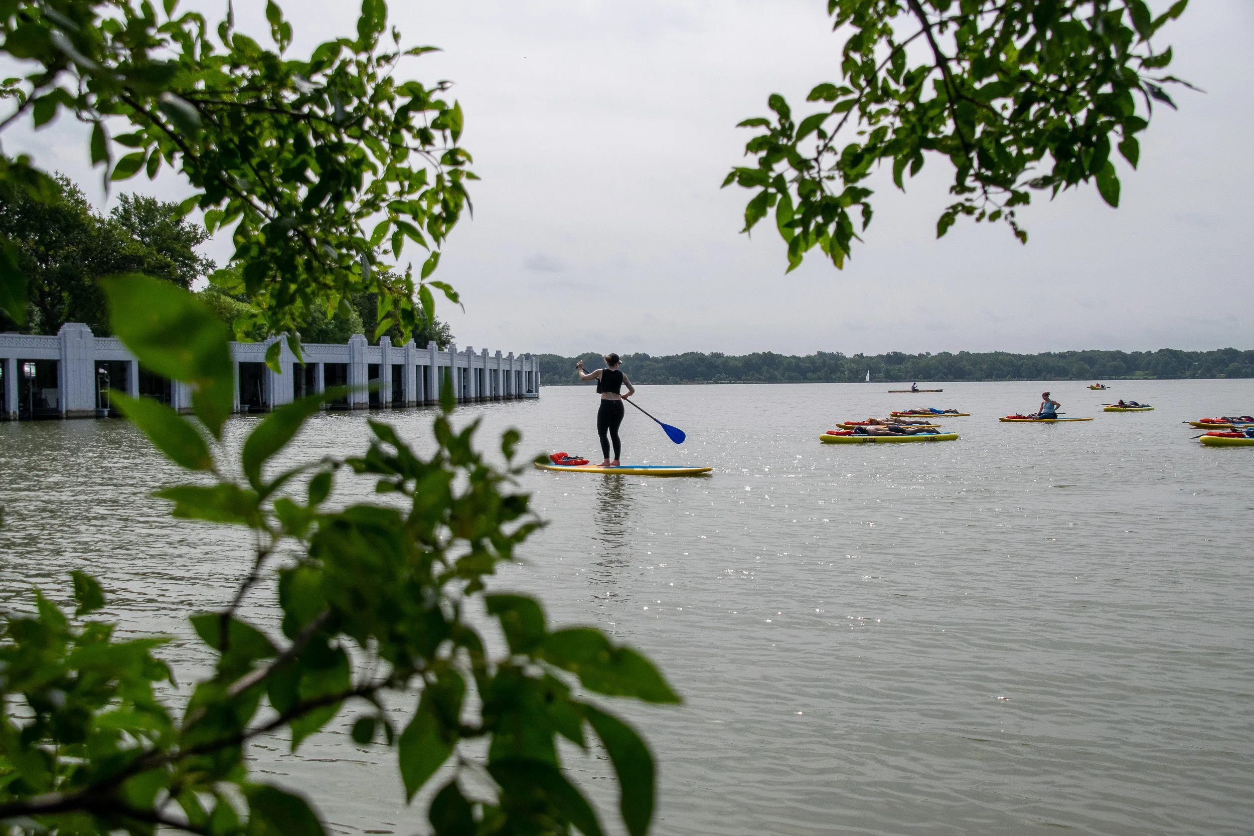 Instructor Tory Christopherson-Sommerfeldt of Just Be Well Yoga surveys her group of paddle boarding yogis in the water at White Rock Lake in Dallas.