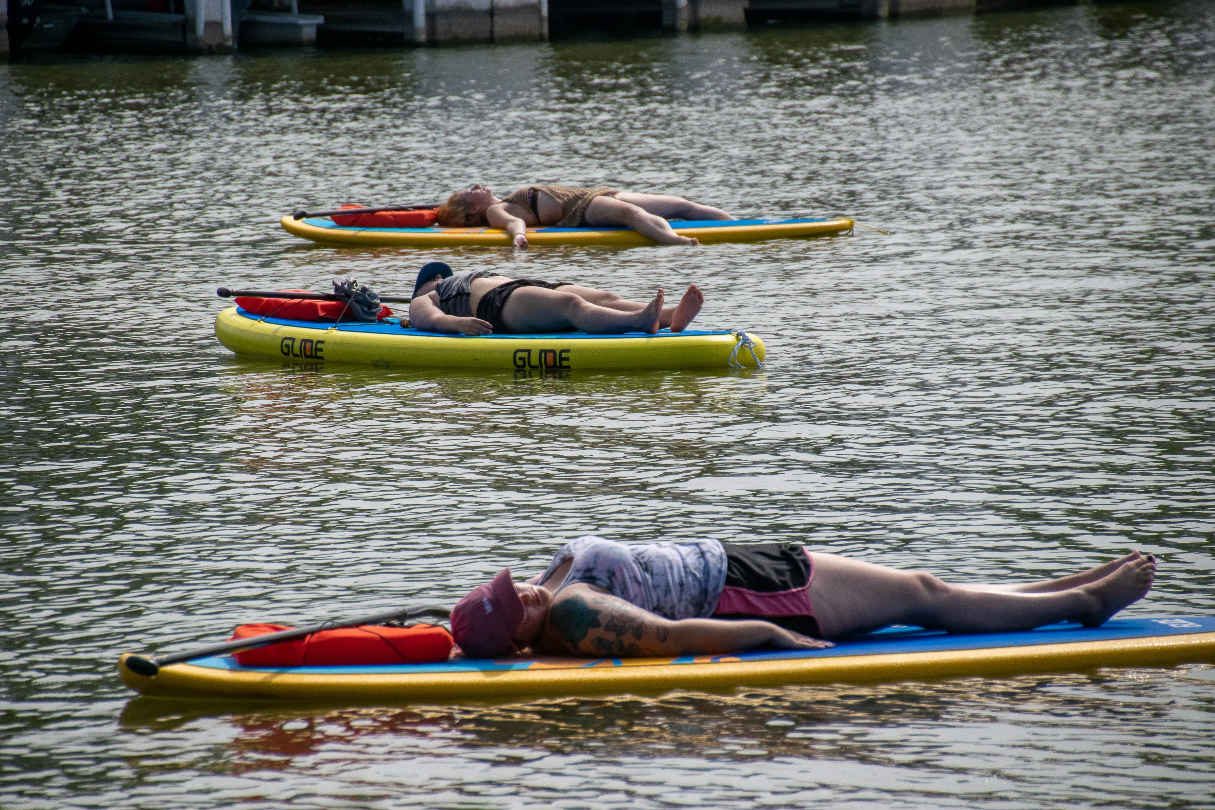 Yogis take their final resting pose, savasana, on their paddle boards on White Rock Lake.