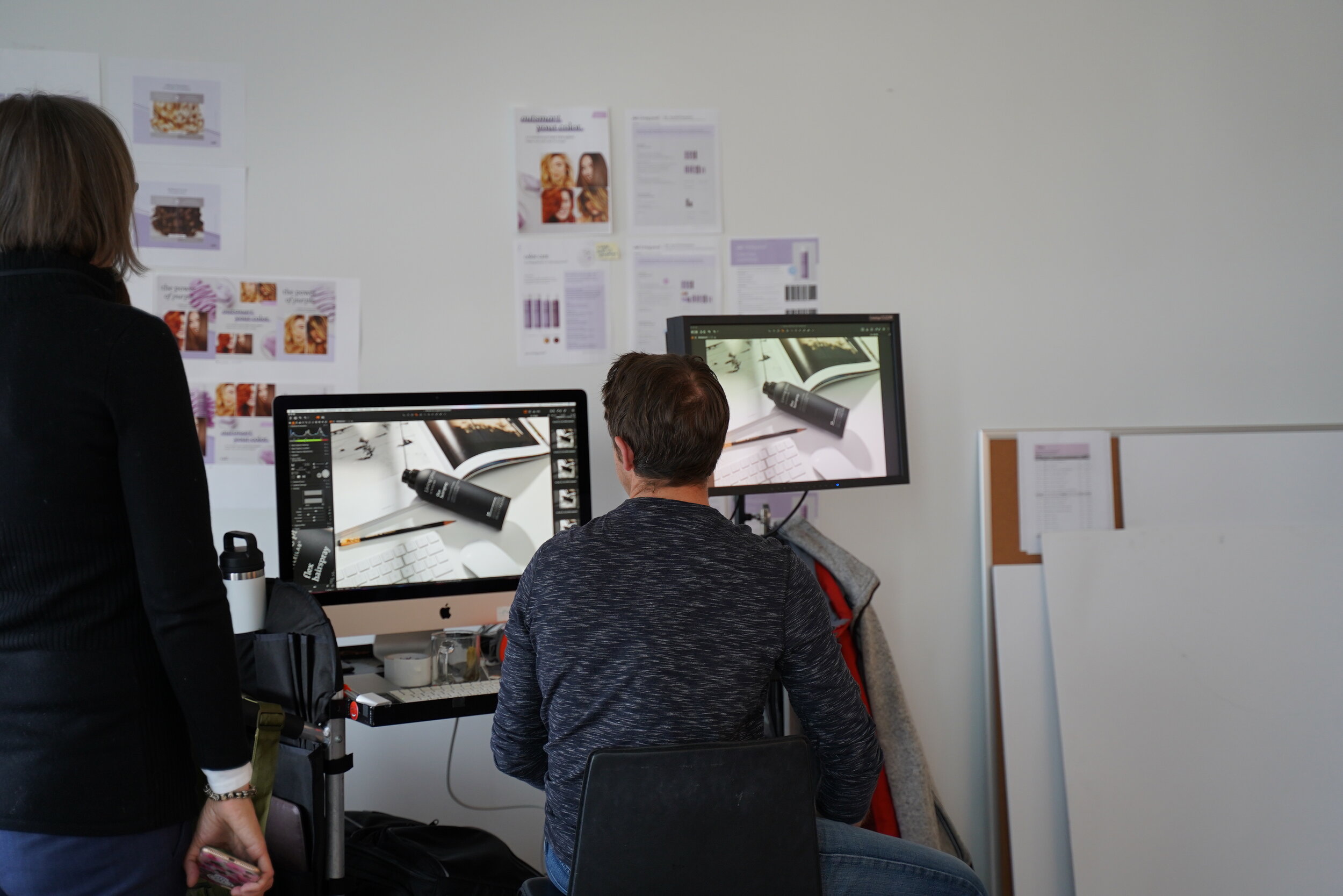 Person viewing images on two monitors in Living Proof office