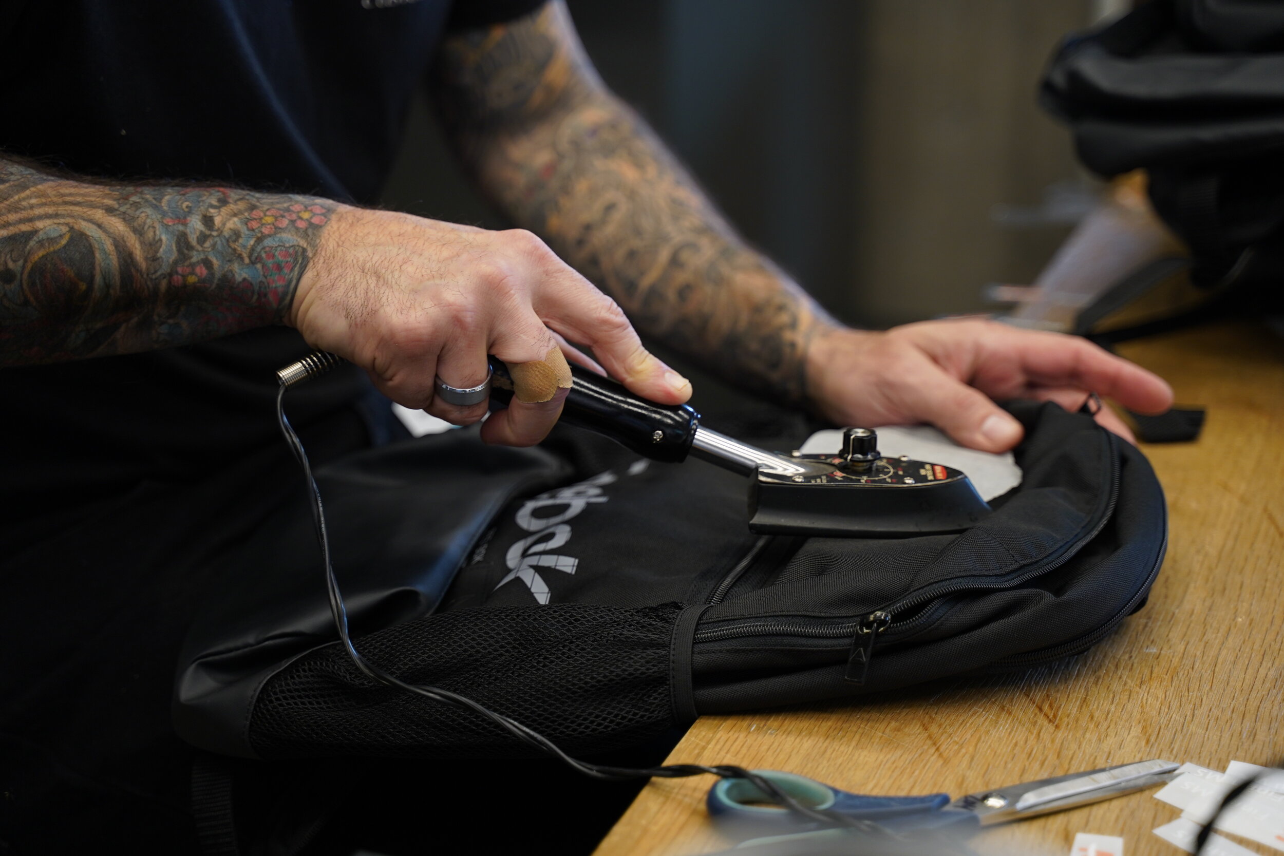 Person working on backpack in Reebok store custom shop 