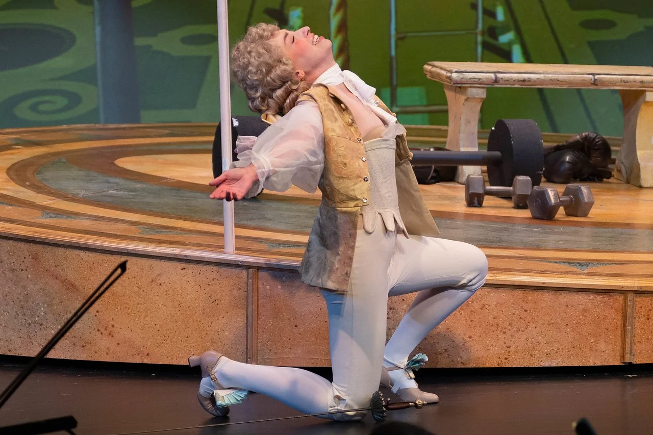  Leslie as Lady Lilette Sauvoirfaire, wearing white pants, gold vest, and blond wig, in  By Georges!  with Lamplighters Music Theatre. Photo by Joe Giammarco. 