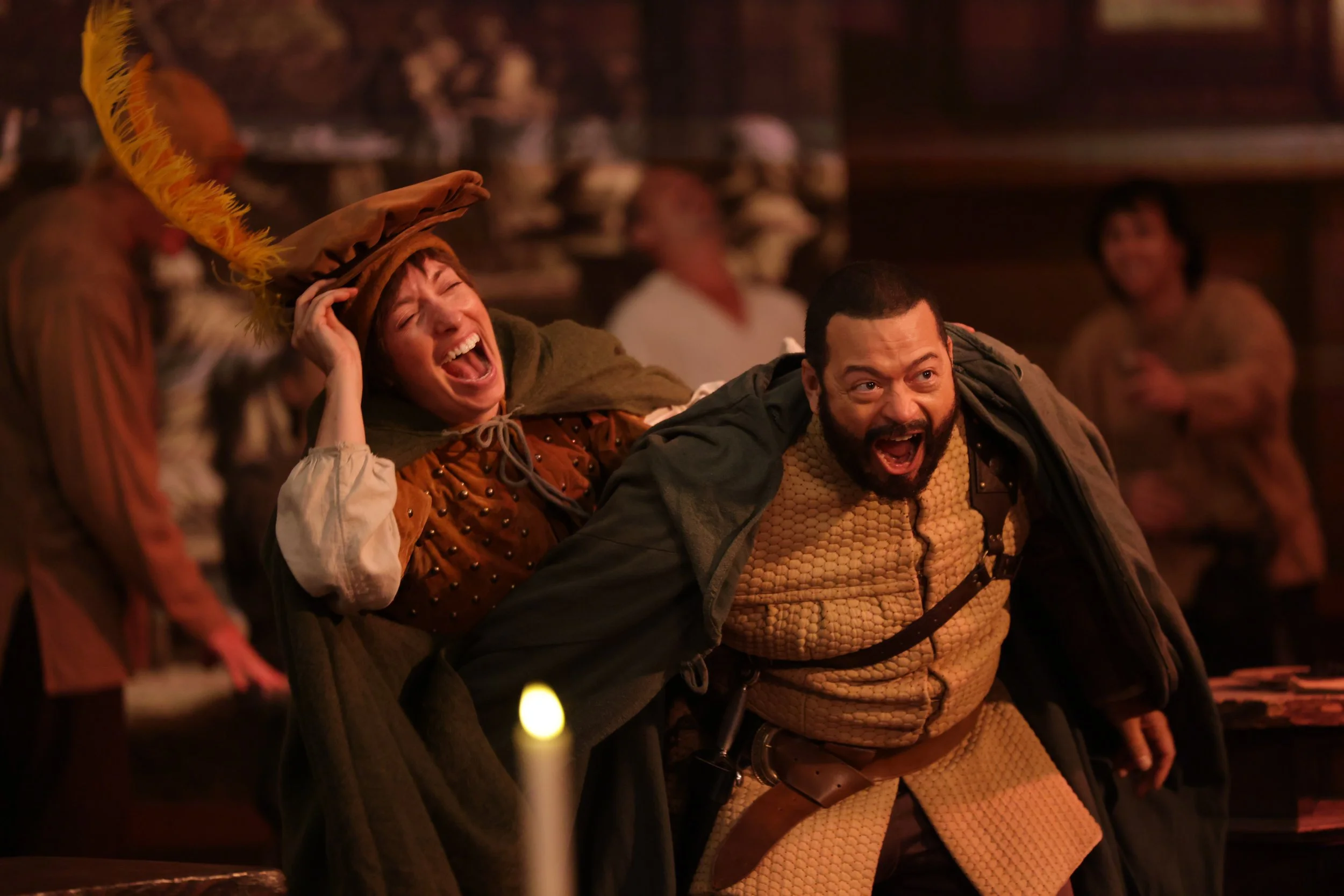  Leslie as Boy, wearing brown shirt, hat with yellow feather, and short wig, in  Plump Jack , pictured with cast mate. Photo by Kathrine Kohl. 