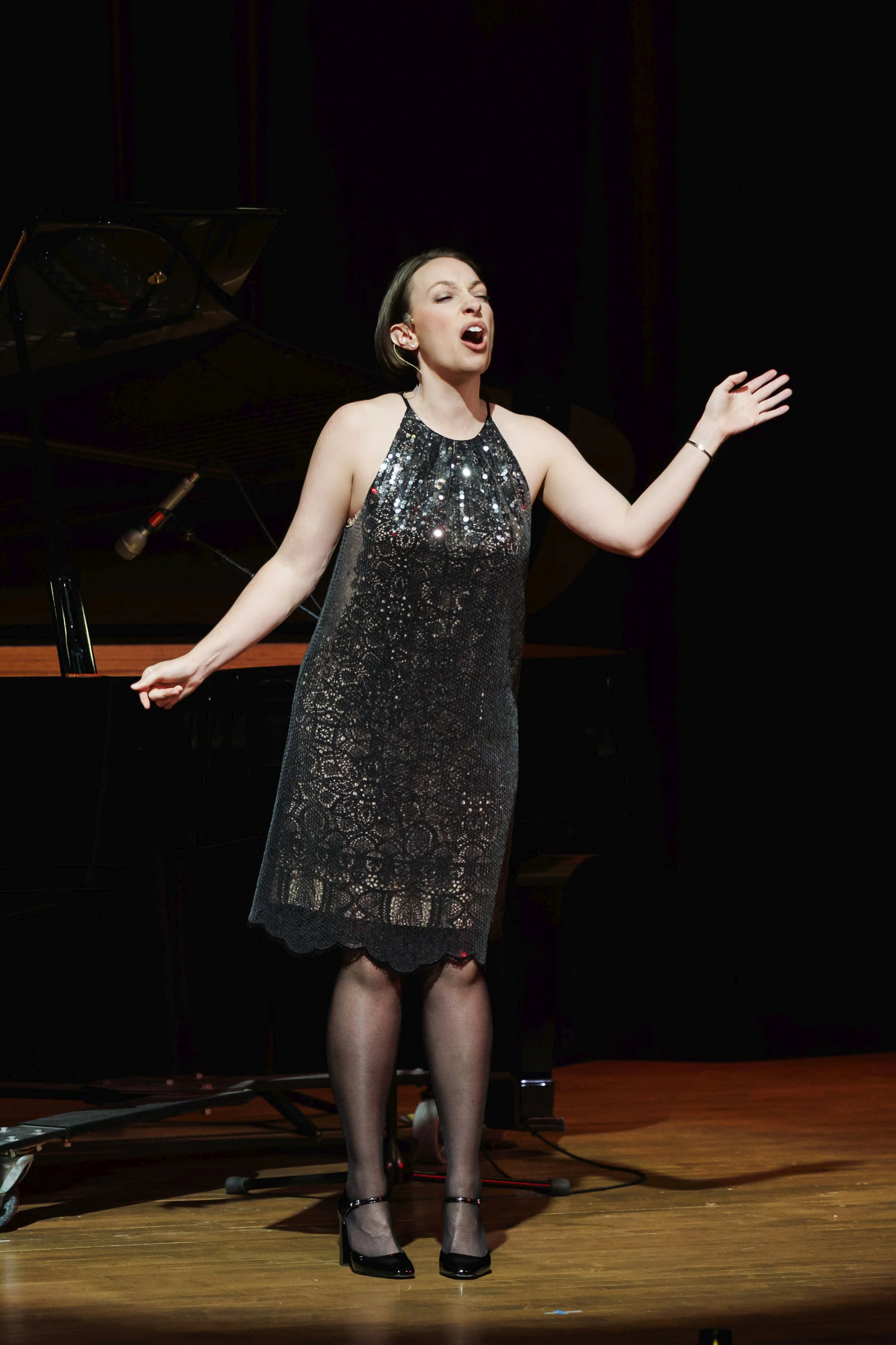 Leslie onstage in short, sequined dress, singing. Photo by Drew Altizer.