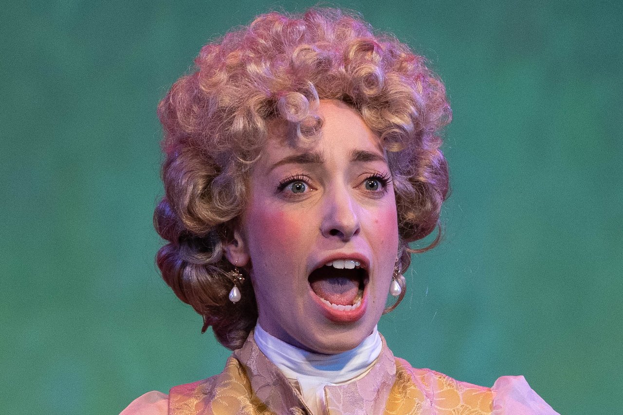  Leslie as Lady Lilette Sauvoirfaire, wearing gold vest and blond wig, in  By Georges!  with Lamplighters Music Theatre. Photo by Joe Giammarco. 