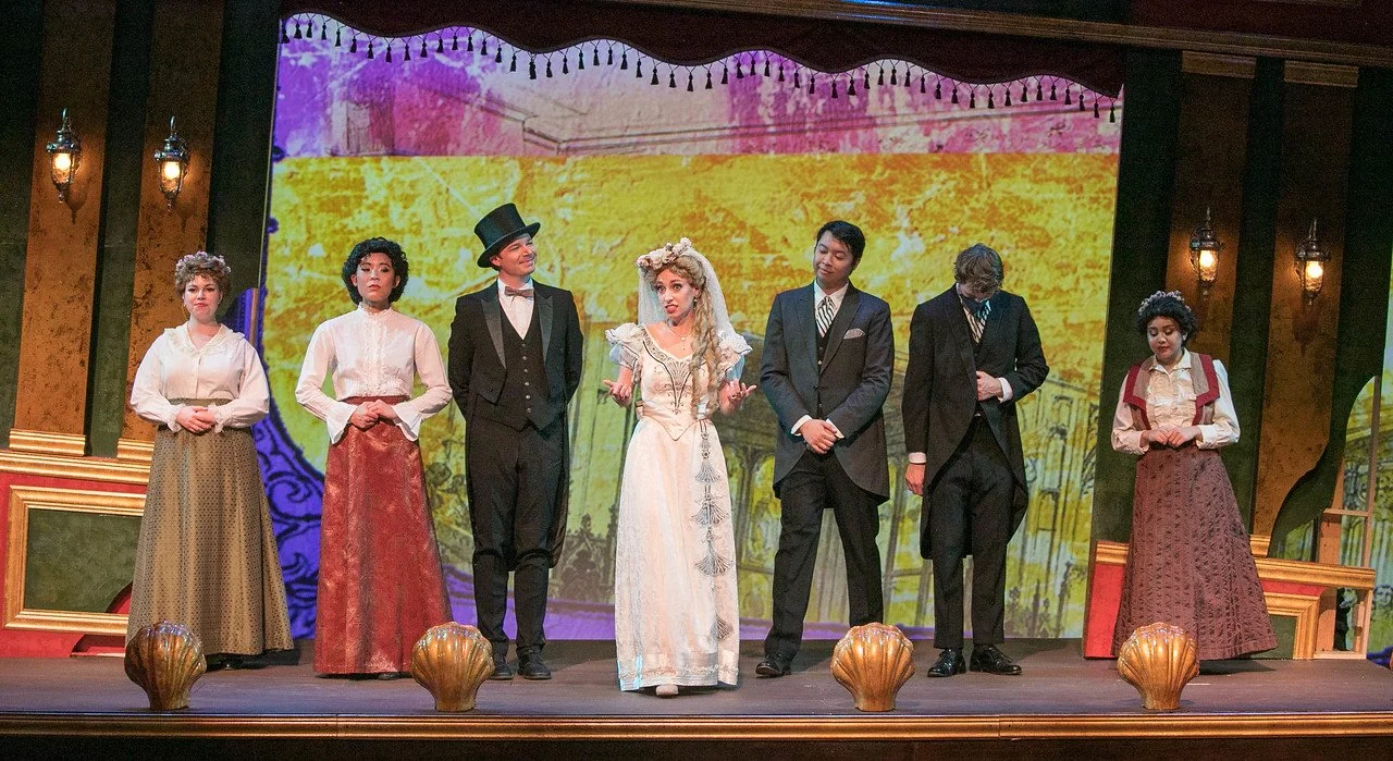  Leslie as Sibella Hallward ,  wearing white wedding dress and blond wig,   in  A Gentleman’s Guide to Love and Murder  with Lamplighters Music Theatre, pictured with castmates. Photo by Lucas Buxman. 